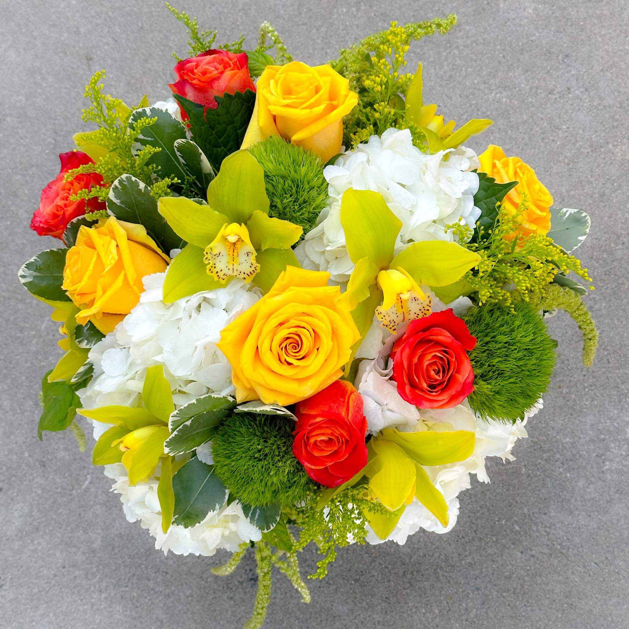 Bouquet of yellow and red roses with white hydrangeas and green orchids