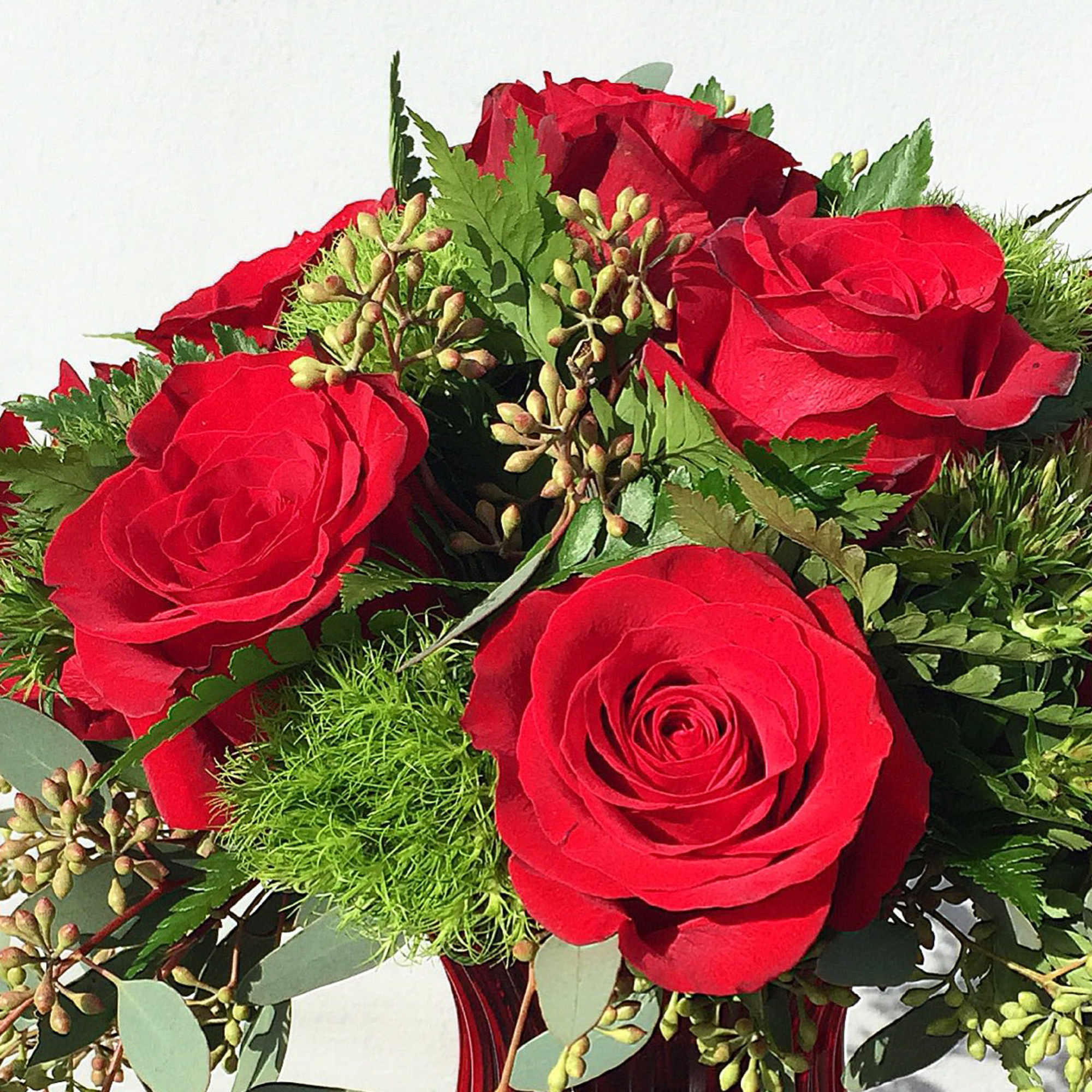 Bouquet of red roses with green filler and foliage