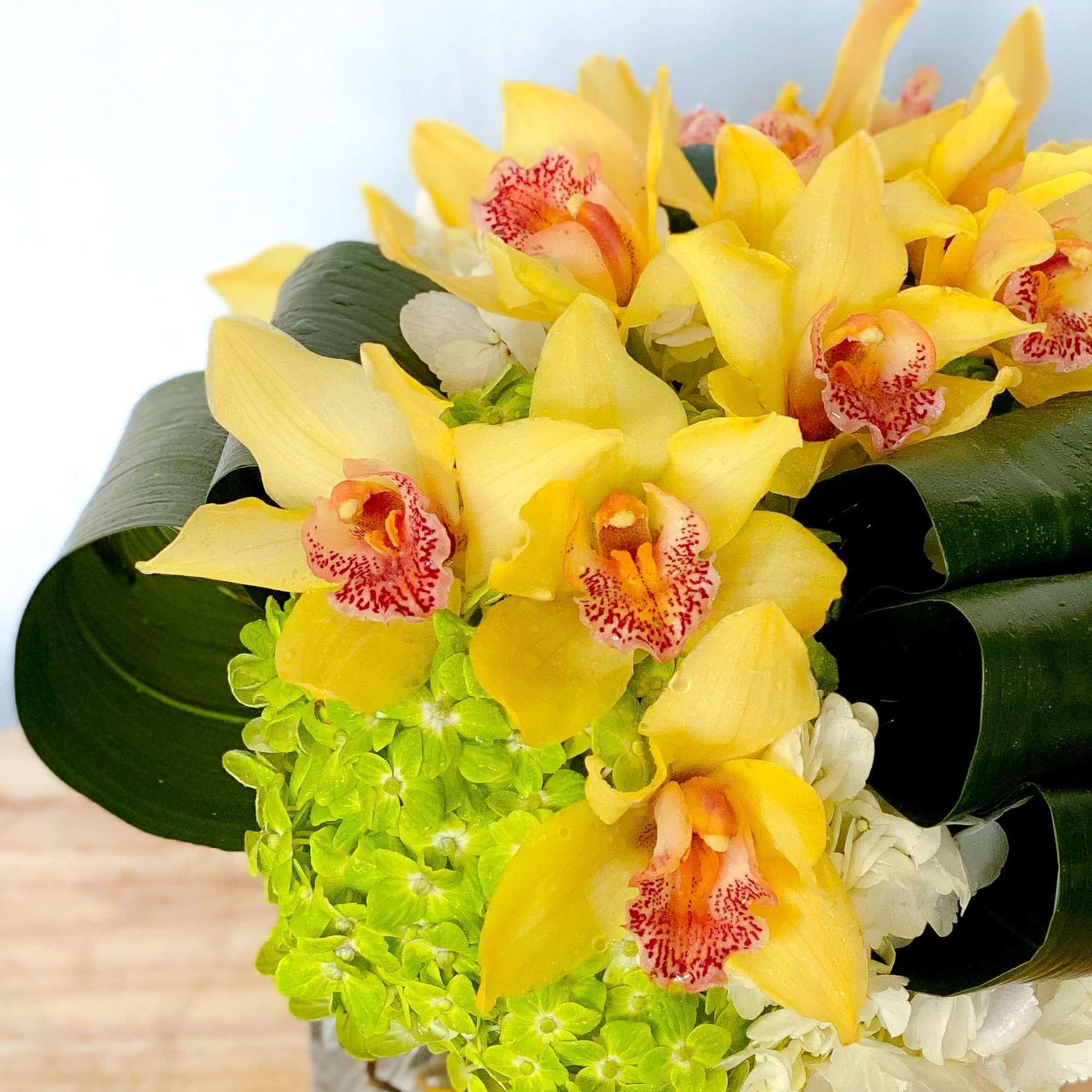 Yellow orchids with green hydrangea and white flowers in a bouquet