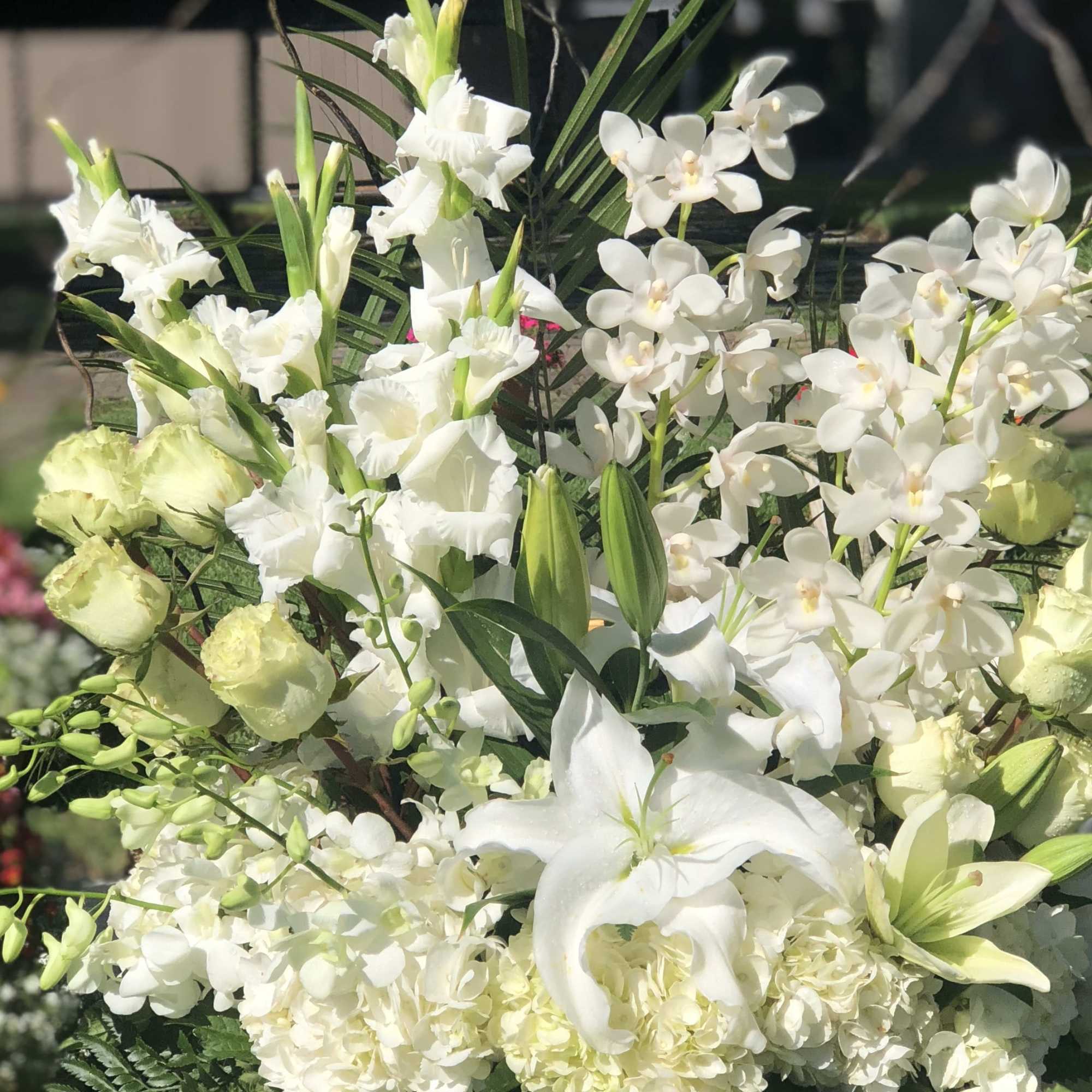 White lilies and orchids arranged with pale green blooms