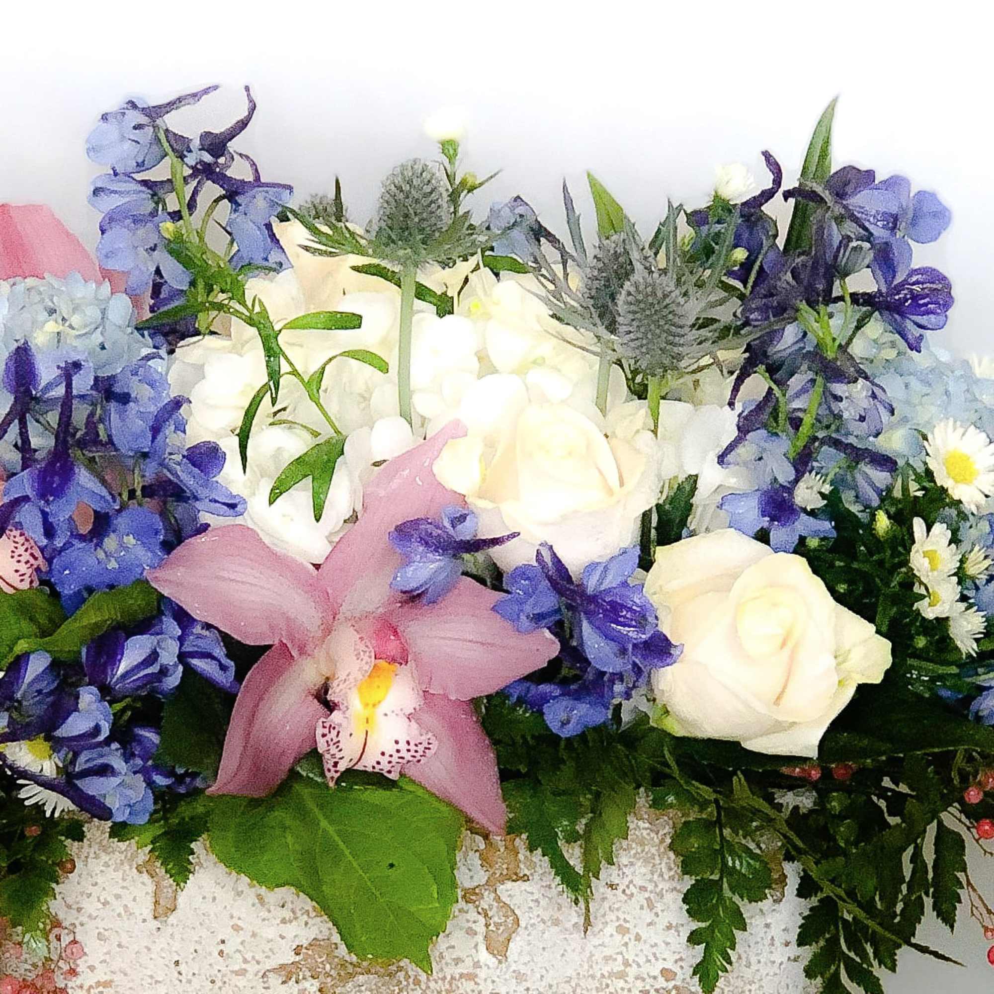 Bouquet of white roses, blue flowers, and a pink orchid