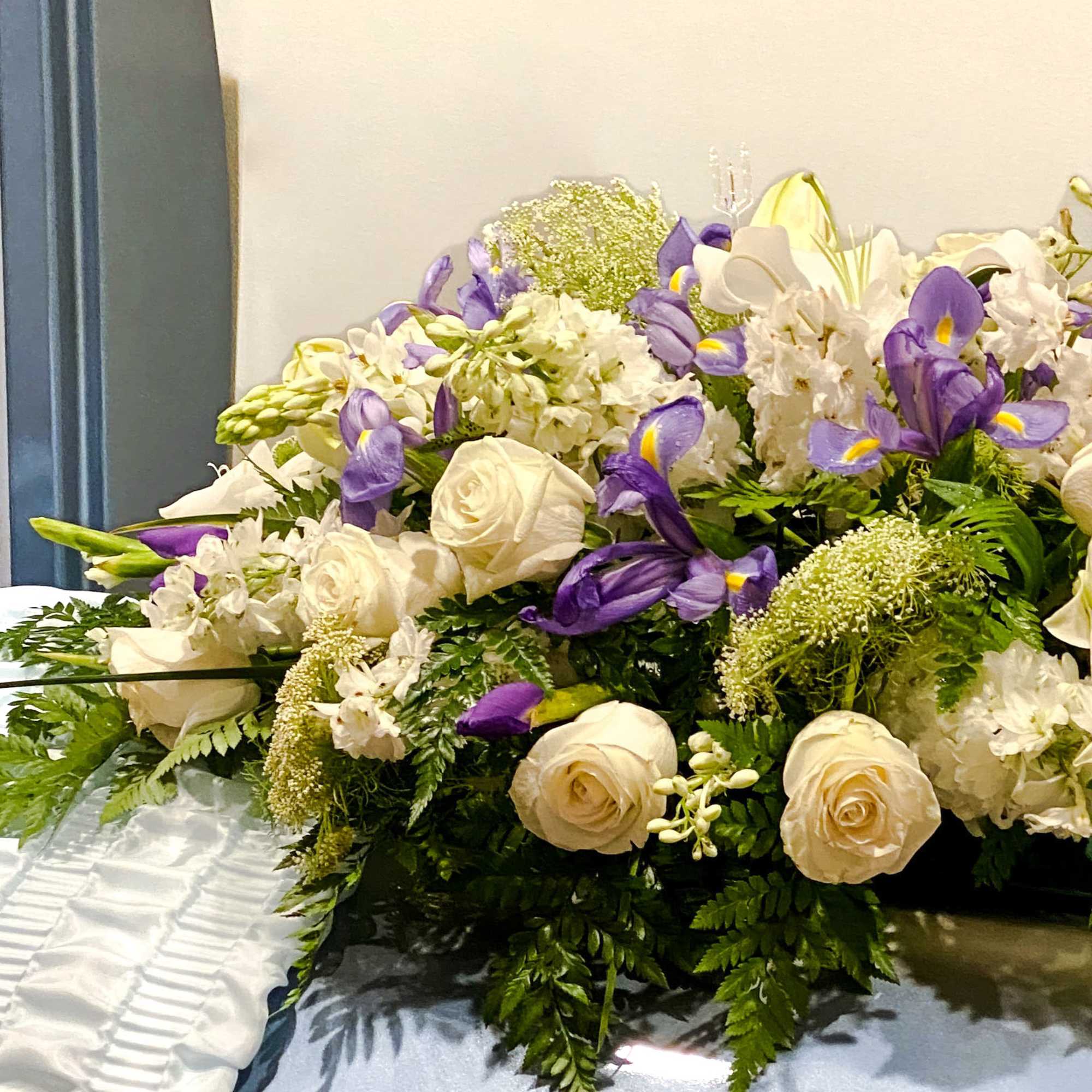 White and purple floral arrangement with roses and irises