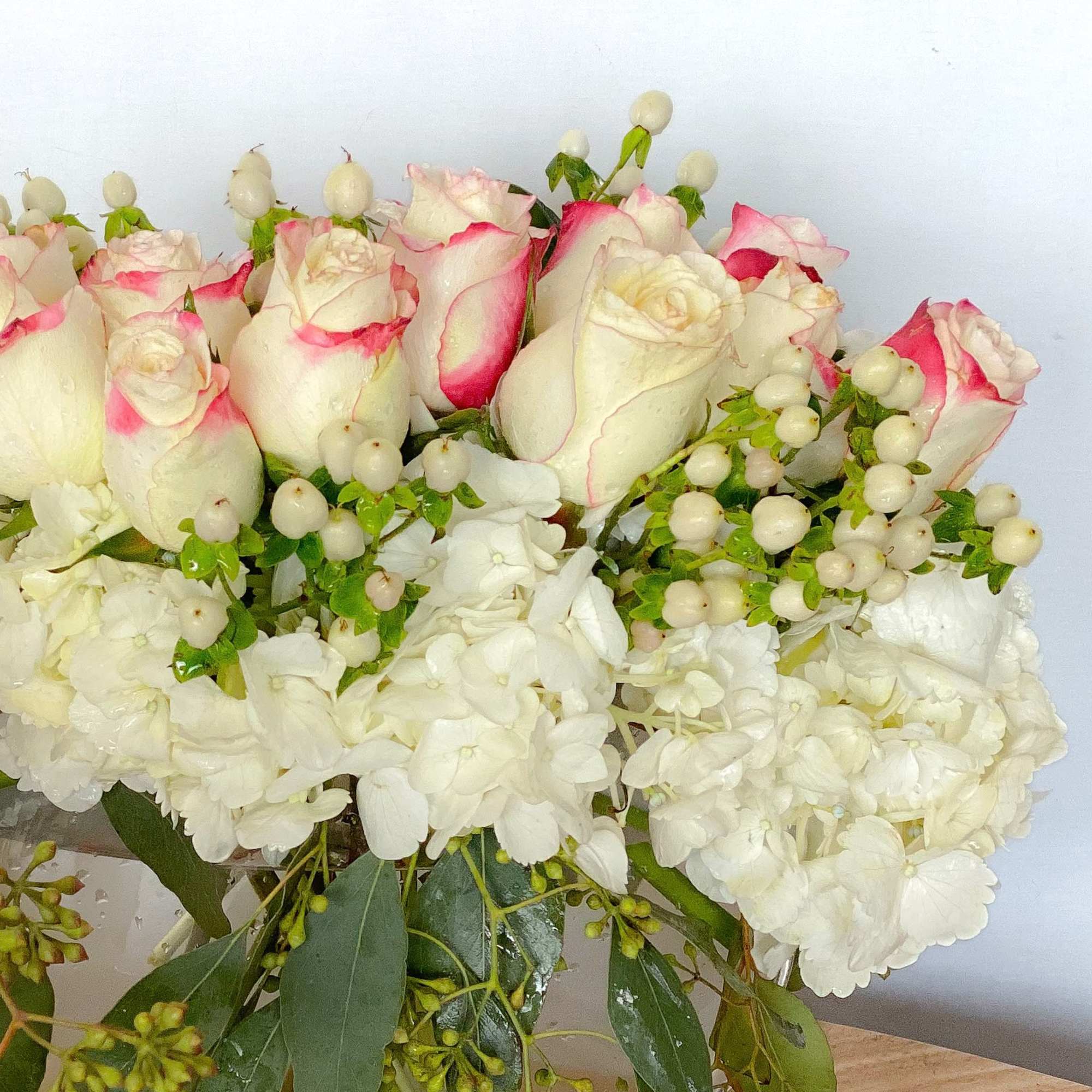 Bouquet of white roses with pink-edged petals and white hydrangeas
