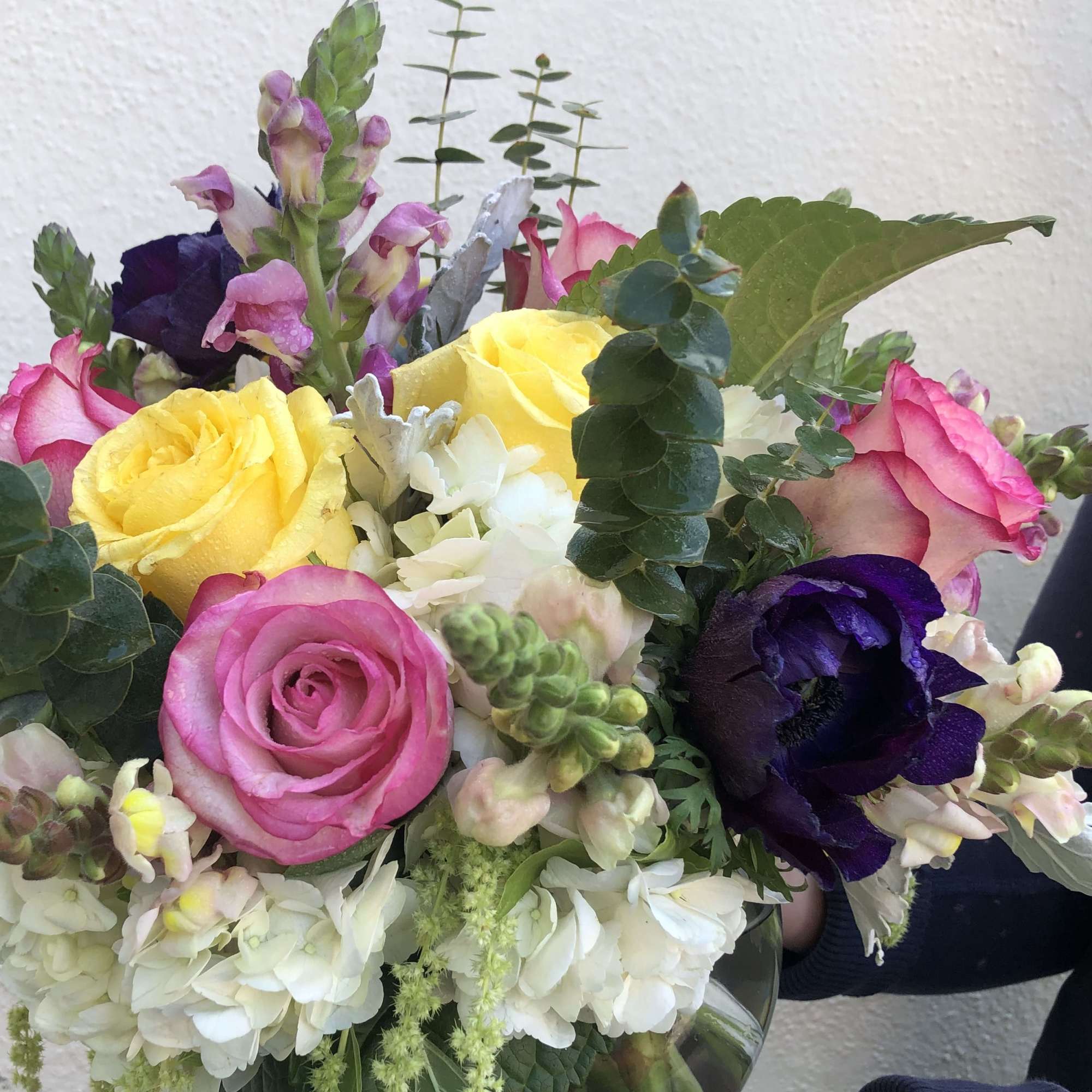 Mixed bouquet of roses, snapdragons, and hydrangeas in bright colors