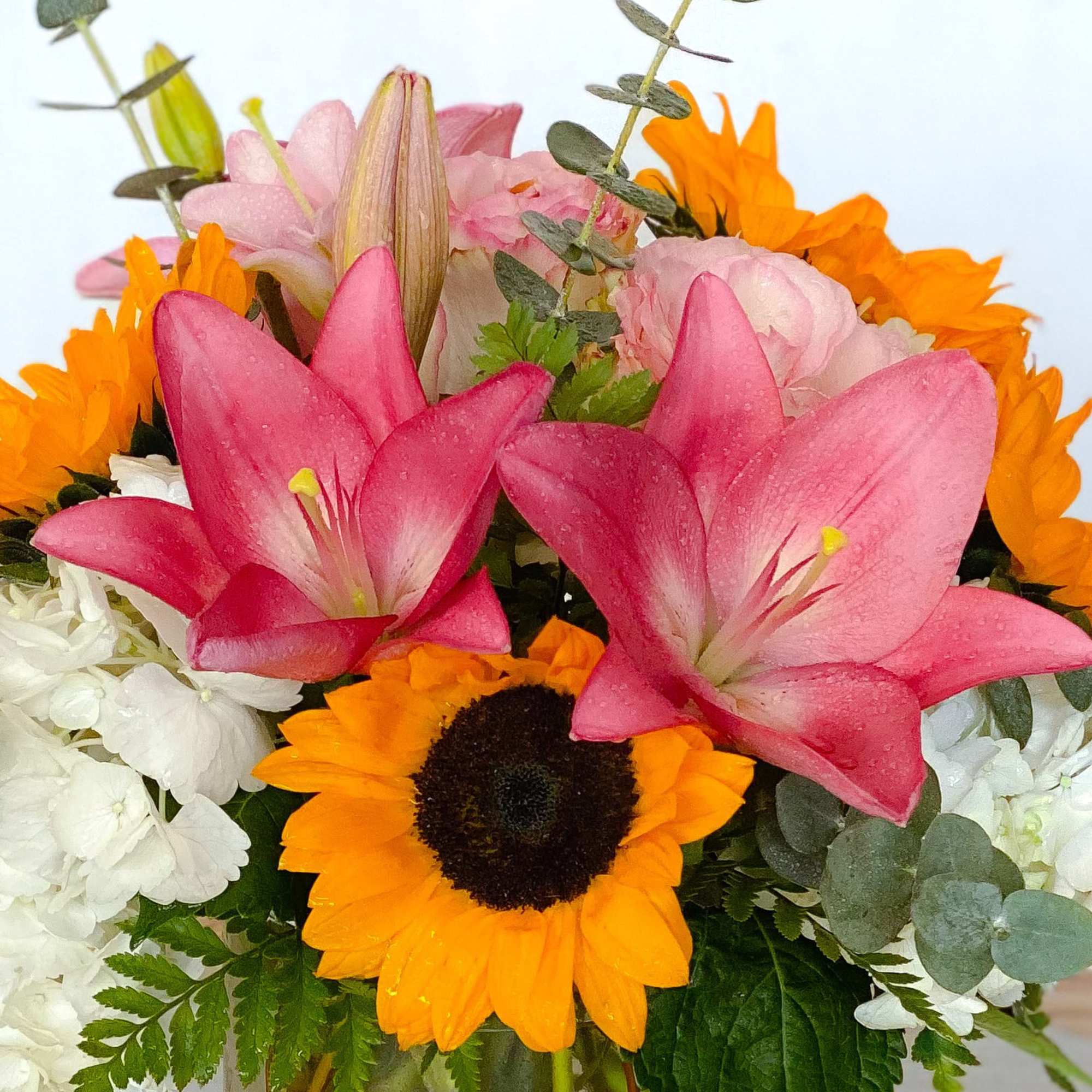 Bouquet with pink lilies, sunflowers, and white flowers