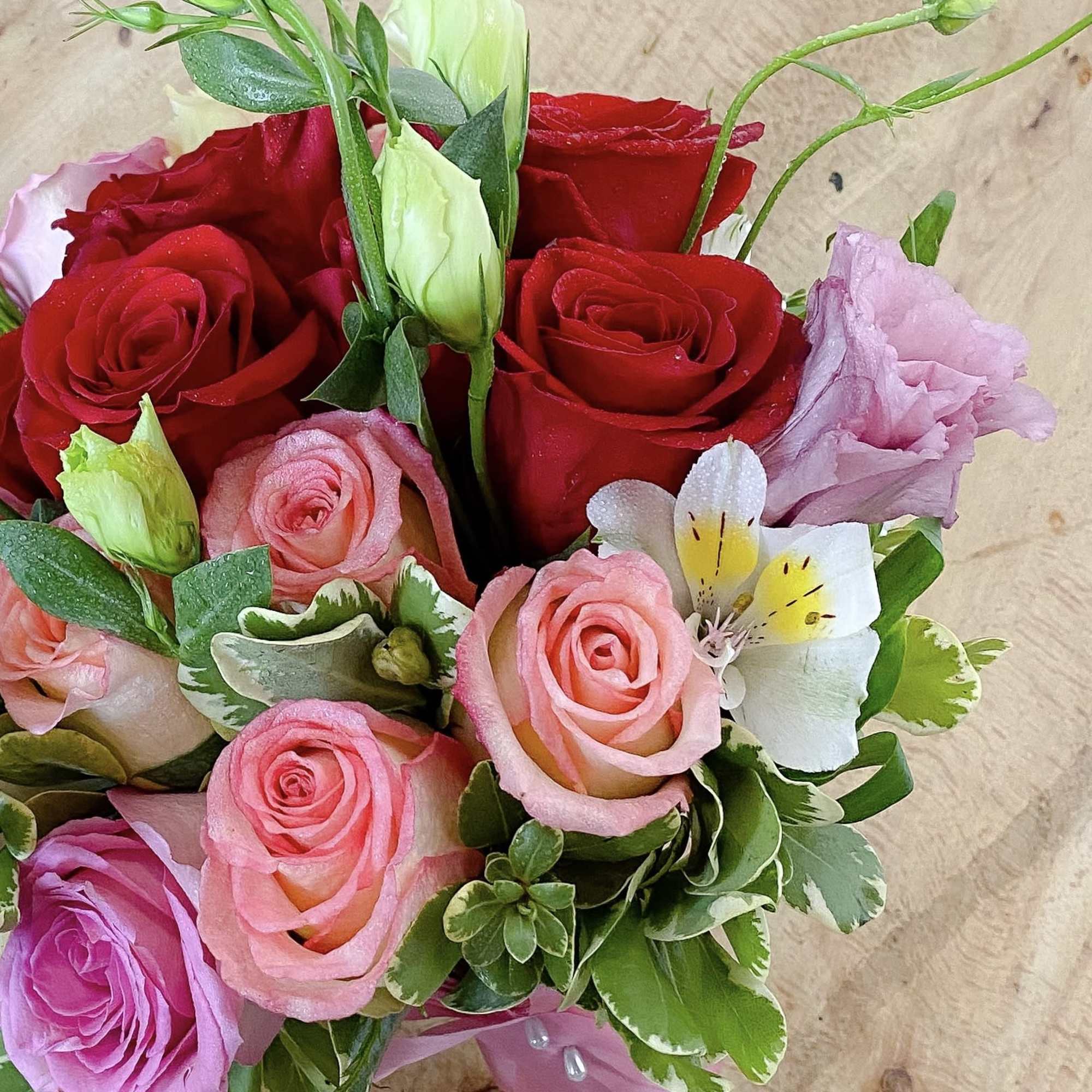 Bouquet of red and pink roses with a white orchid bloom