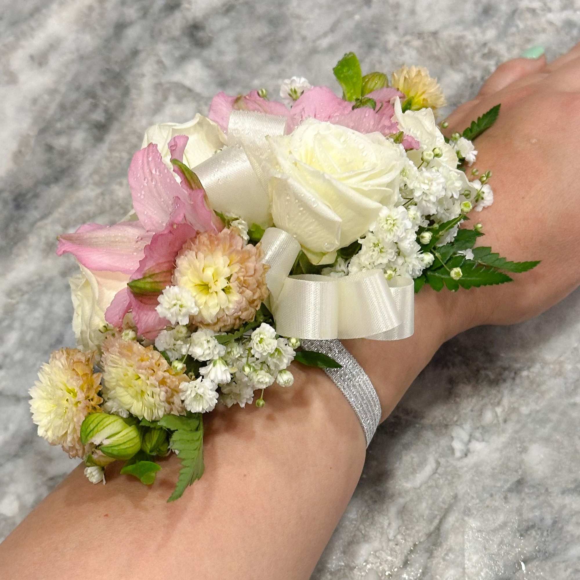 Pink and white floral wrist corsage with ribbon