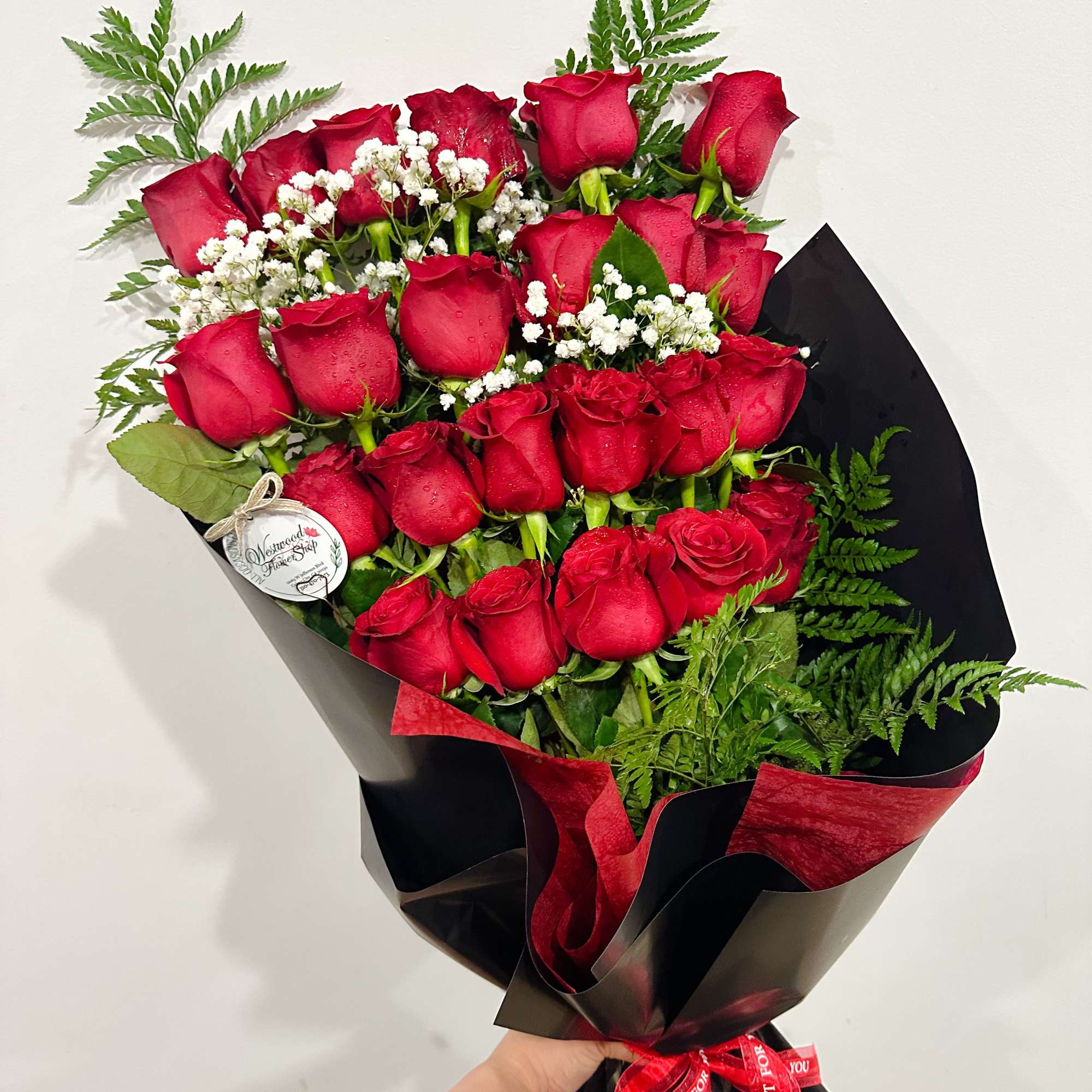 Bouquet of red roses with baby's breath in black and red wrap