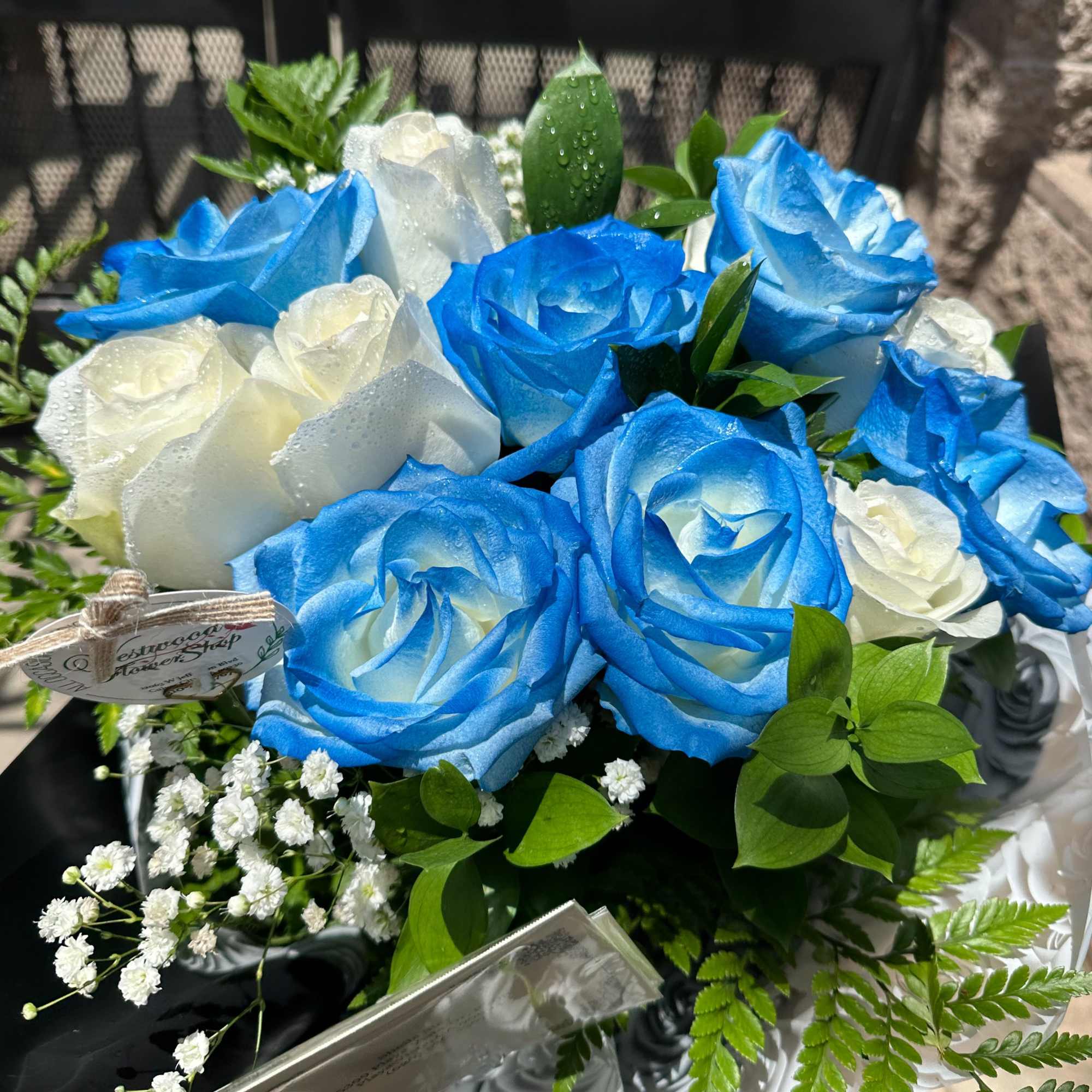 Blue and white rose bouquet with baby's breath and greenery