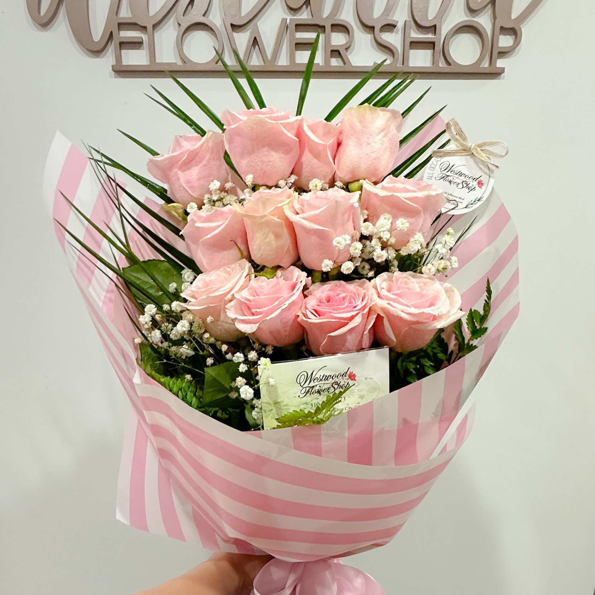 Bouquet of pink roses wrapped in pink striped paper