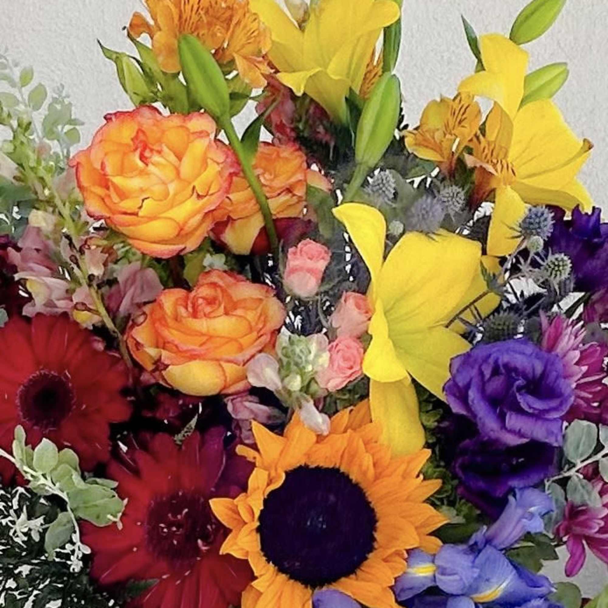 Colorful mixed bouquet with lilies, roses, gerbera daisies, and a sunflower