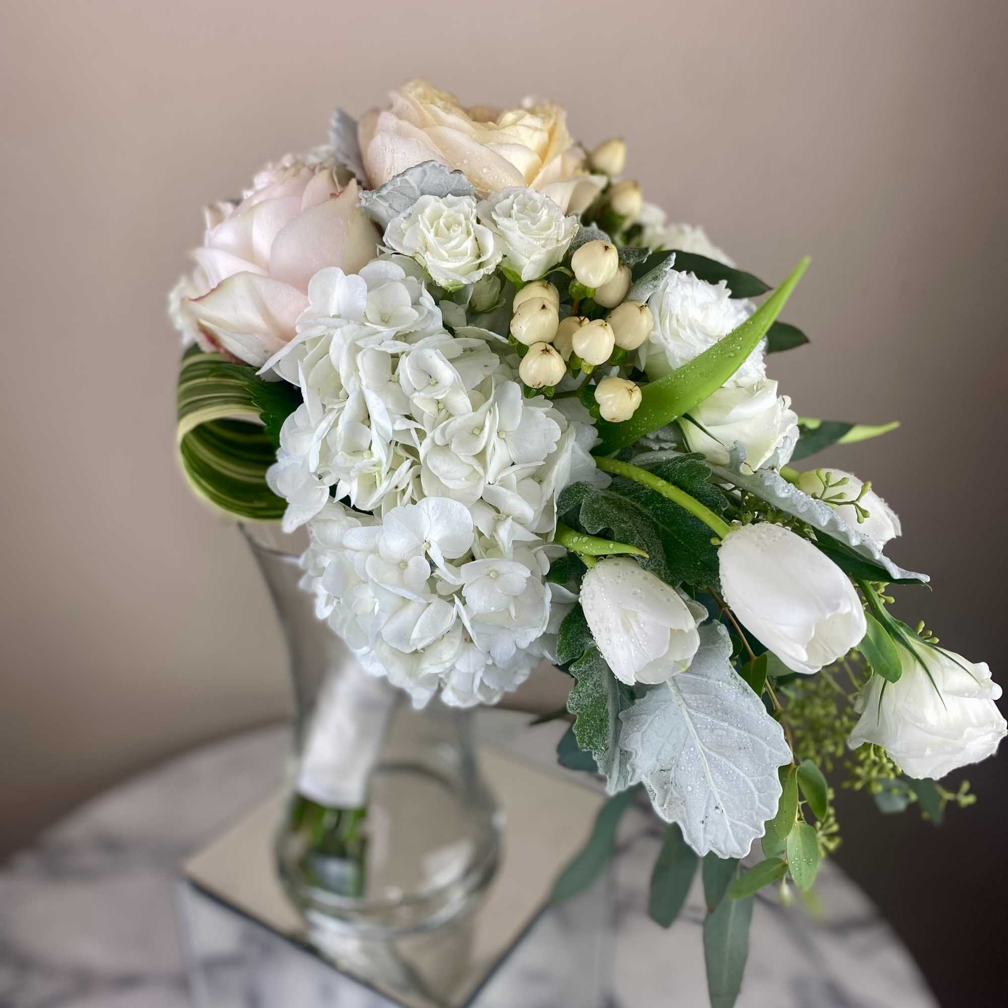 White and blush bouquet in a clear glass vase