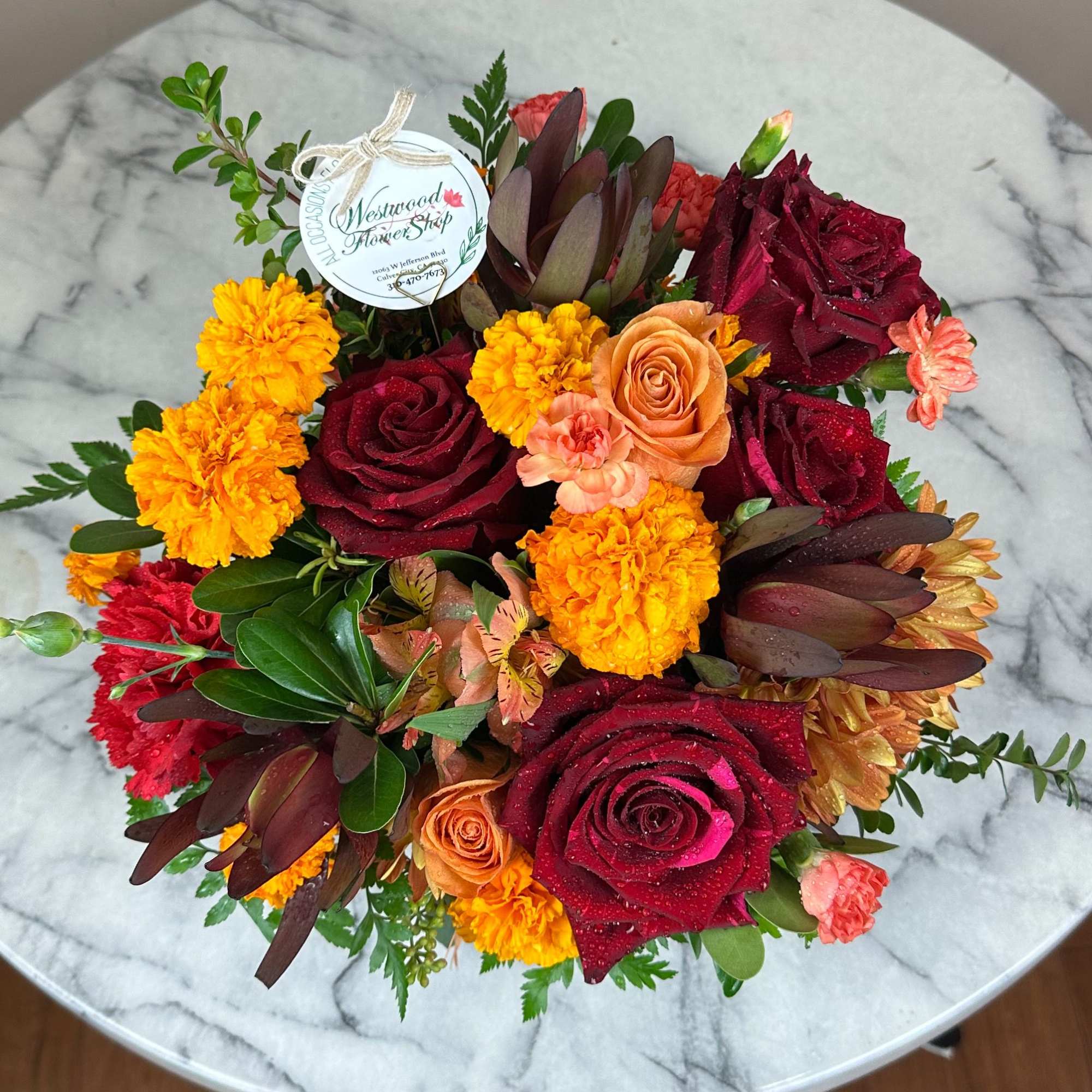 Bouquet of red and orange roses with yellow marigolds