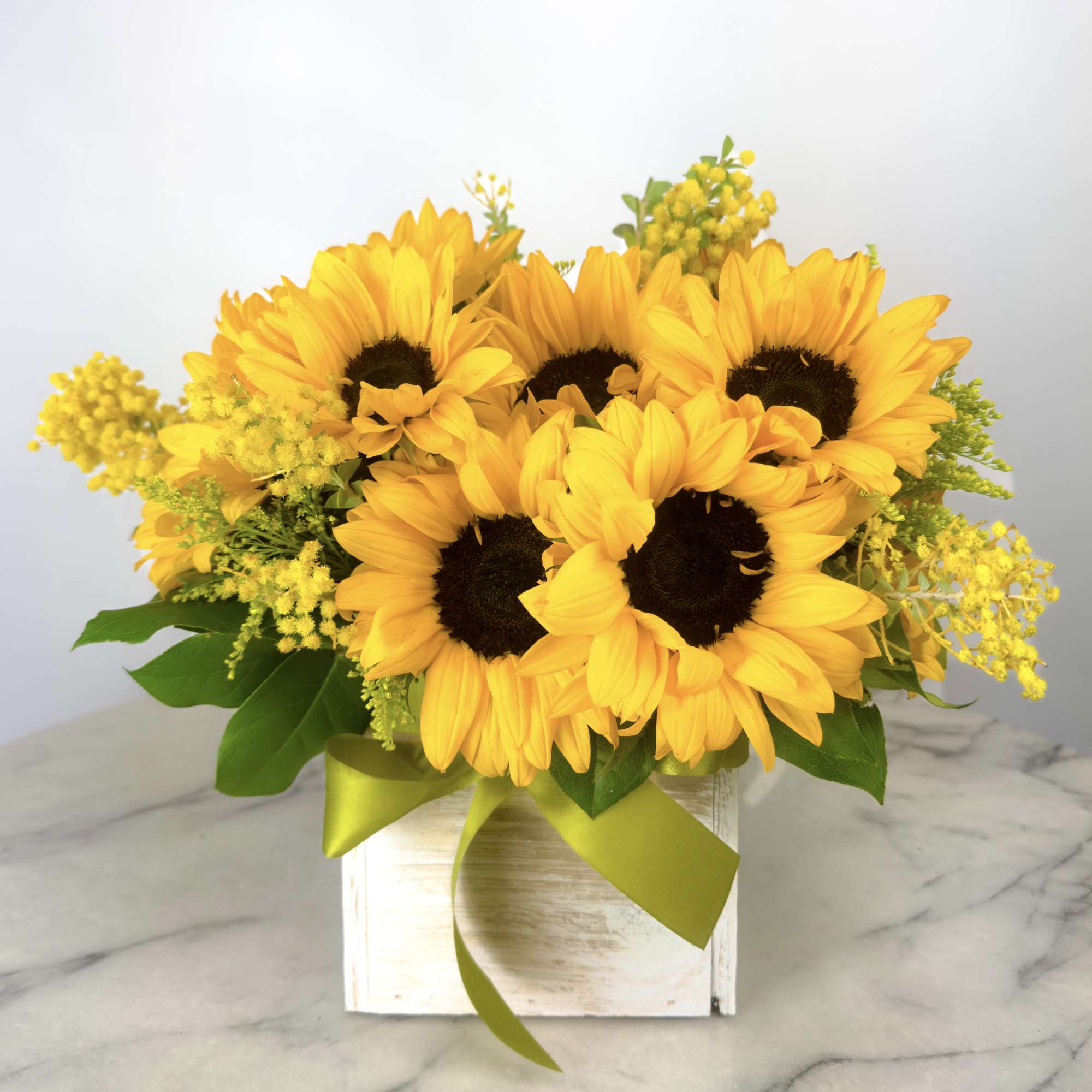 Sunflower arrangement in a white box with a green ribbon