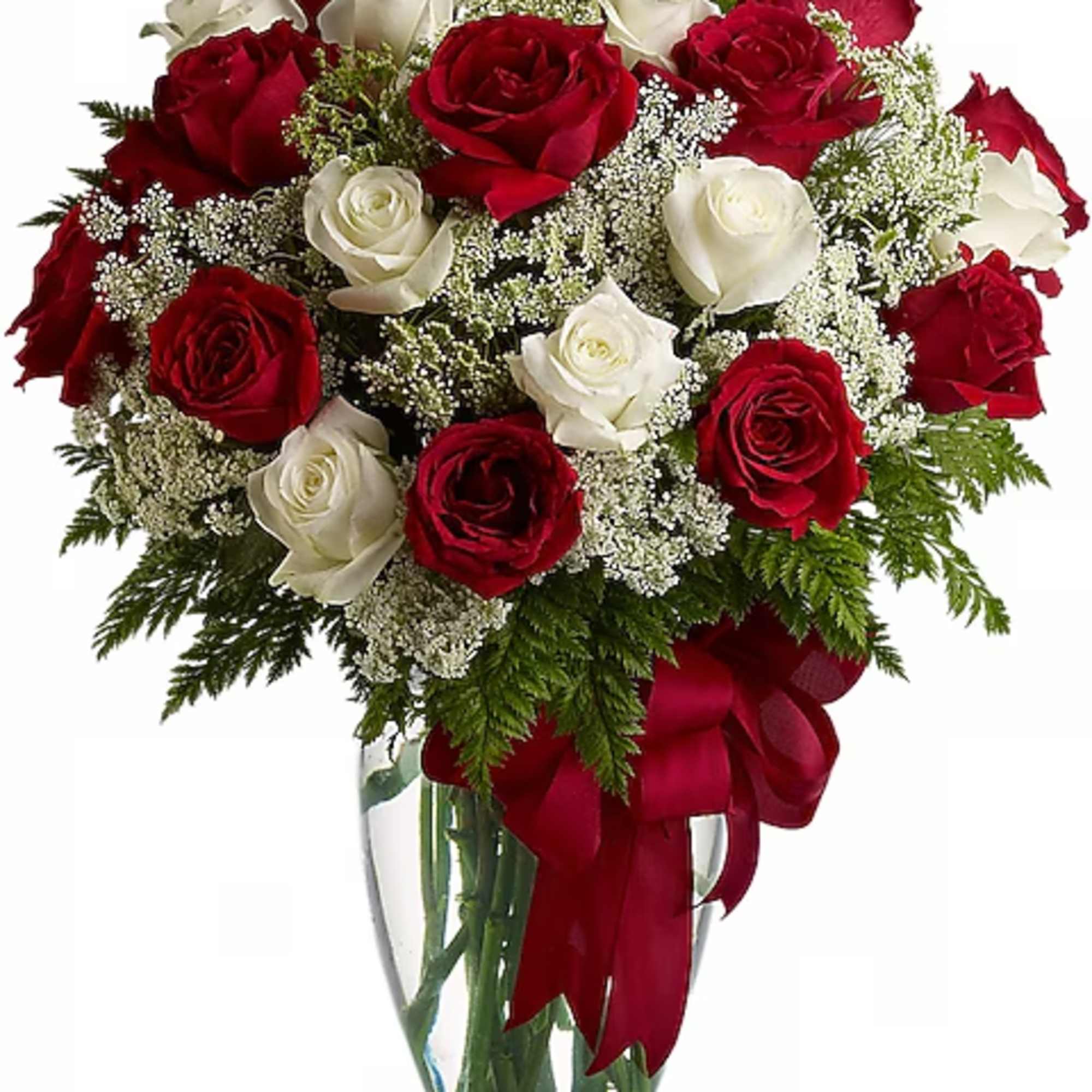 Red and white roses arranged in a clear glass vase with a red ribbon