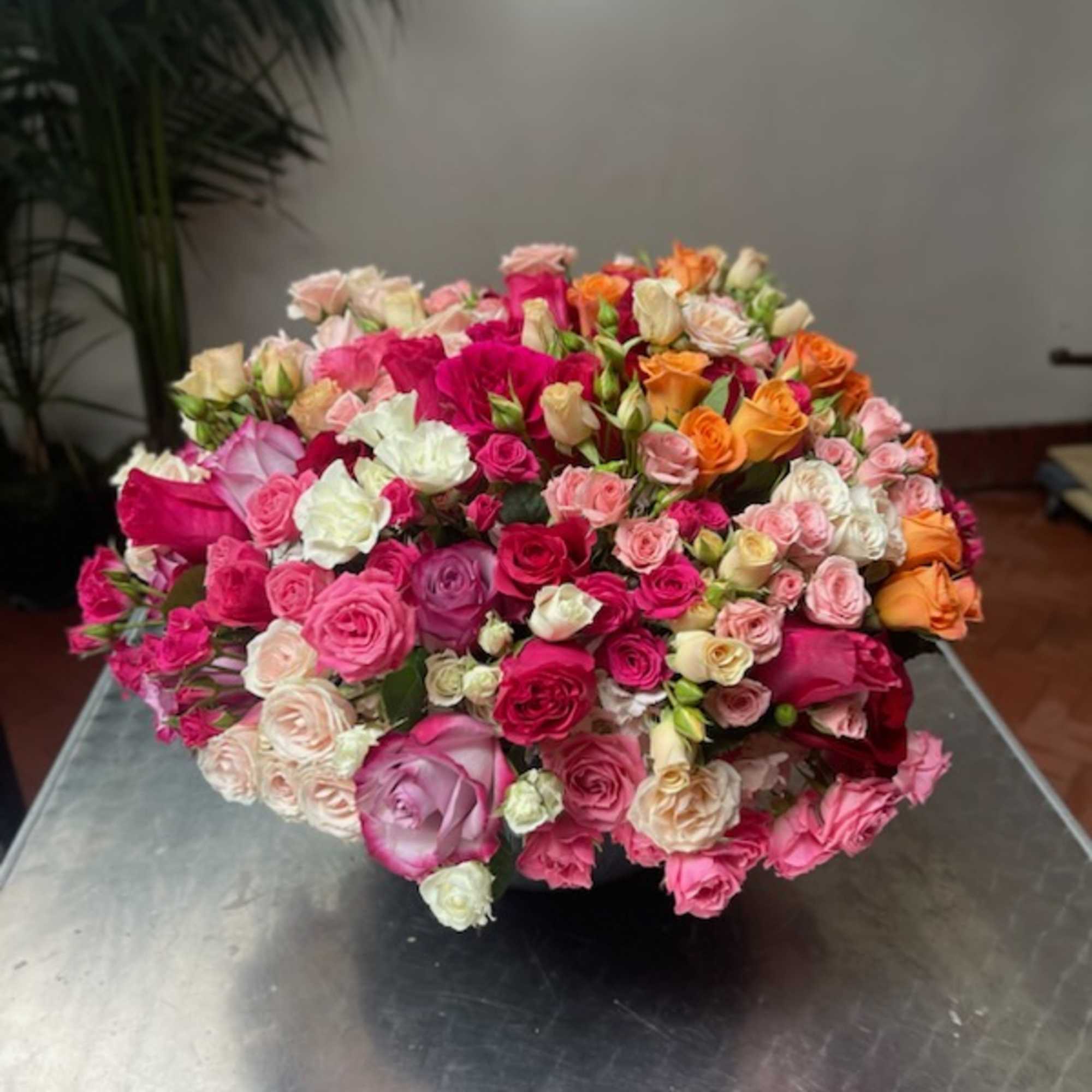 Large bouquet of multicolored roses in a low container
