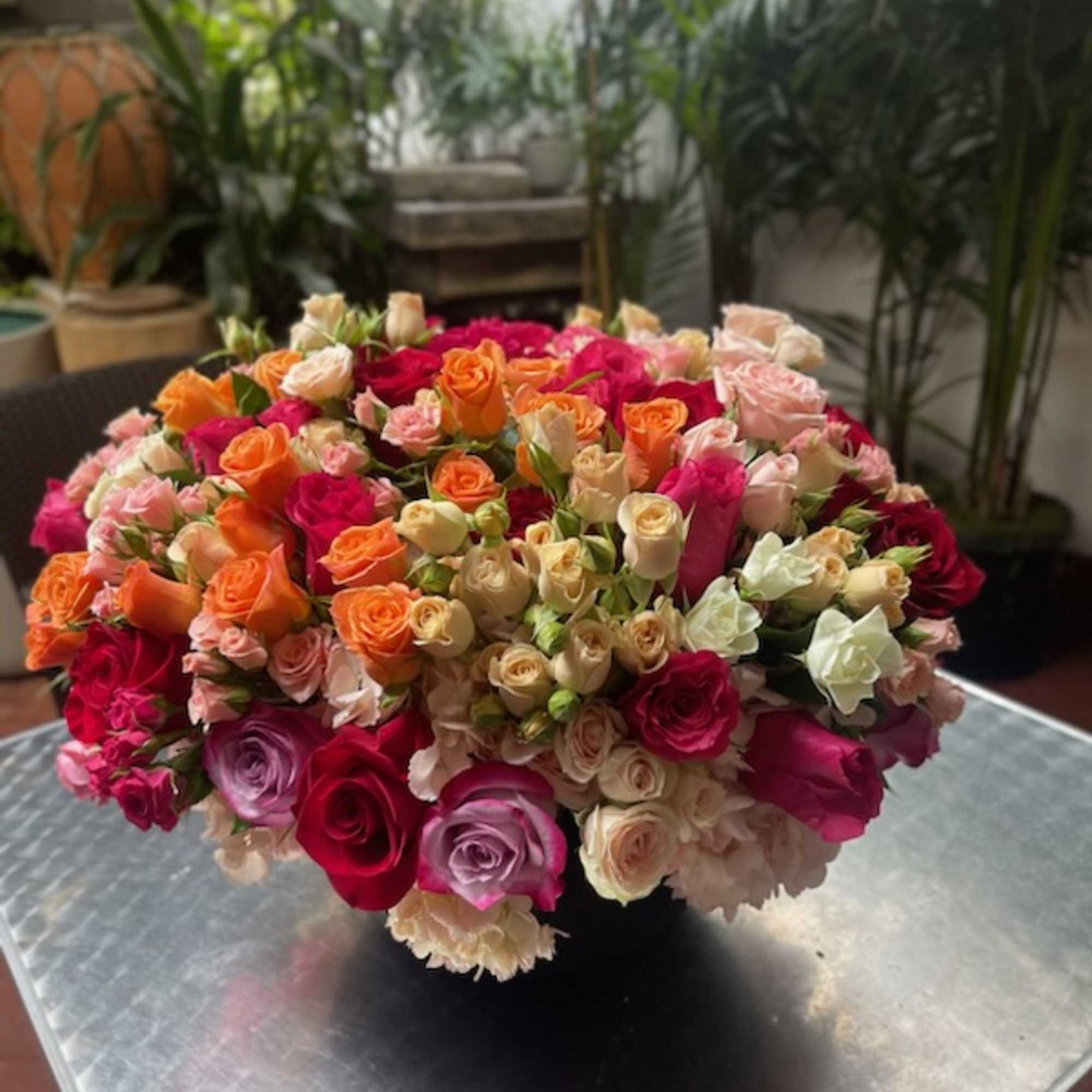 Large bouquet of multicolored roses in a low black container
