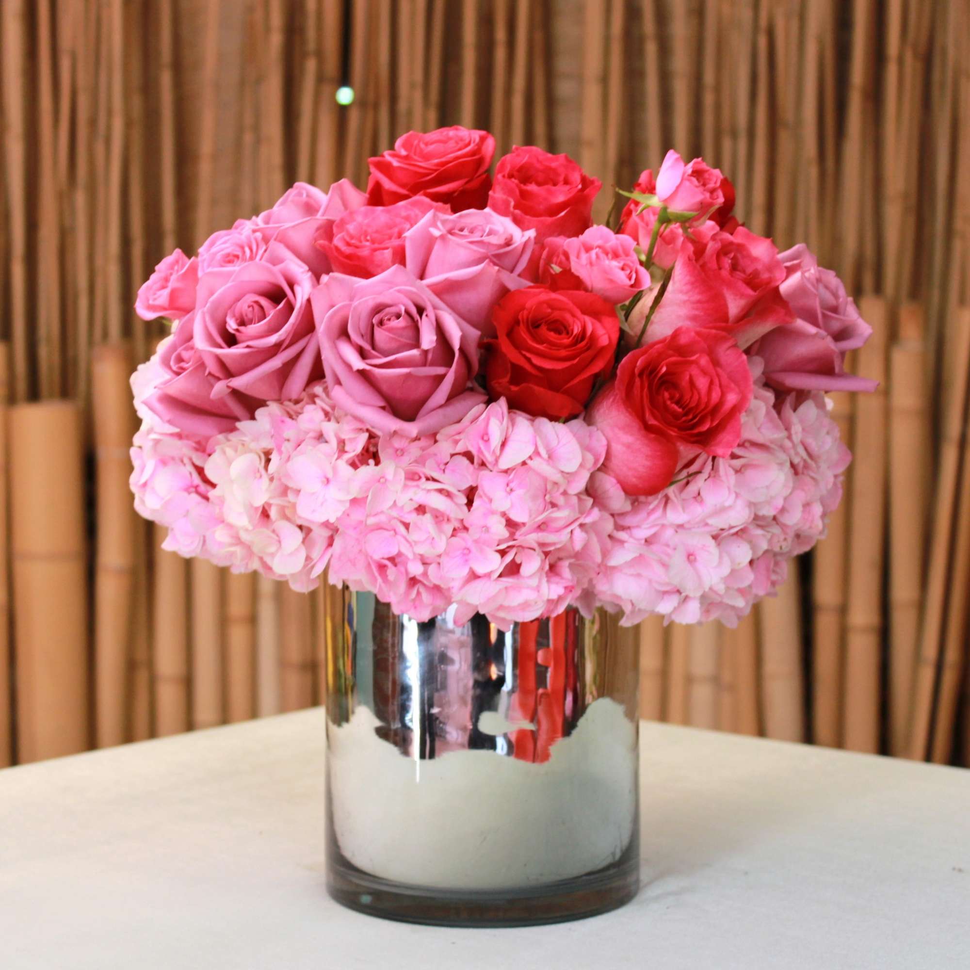 Pink and red roses arranged in a mirrored vase, photo 2 of 3