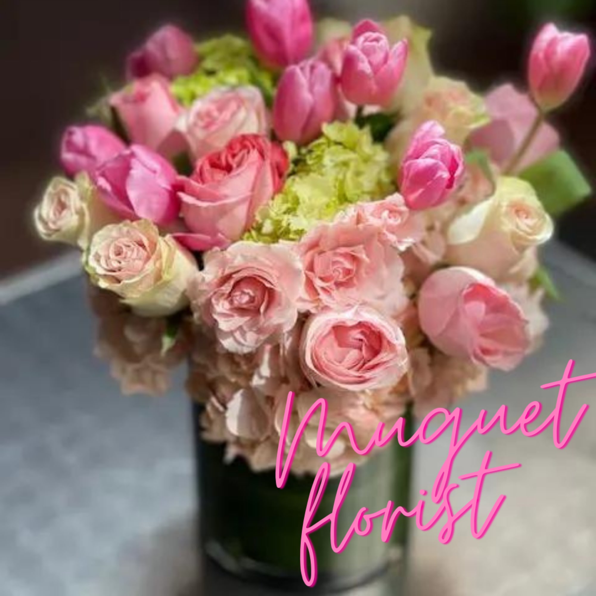 Pink and cream roses with tulips in a dark vase