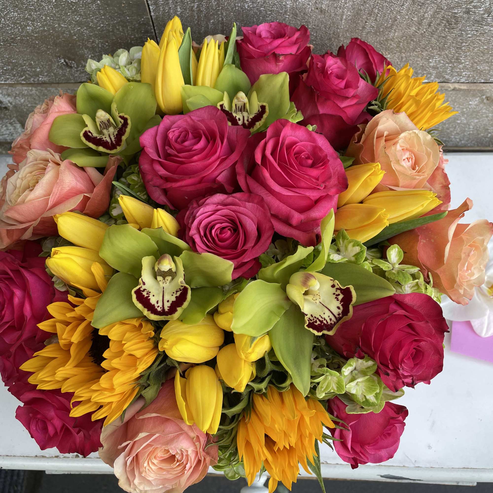 Bouquet of hot pink and peach roses with yellow tulips and sunflowers