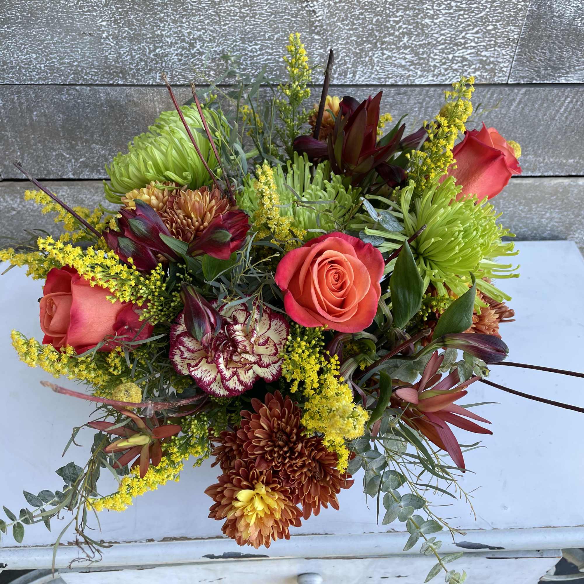 Mixed bouquet with coral roses, chrysanthemums, and yellow filler flowers