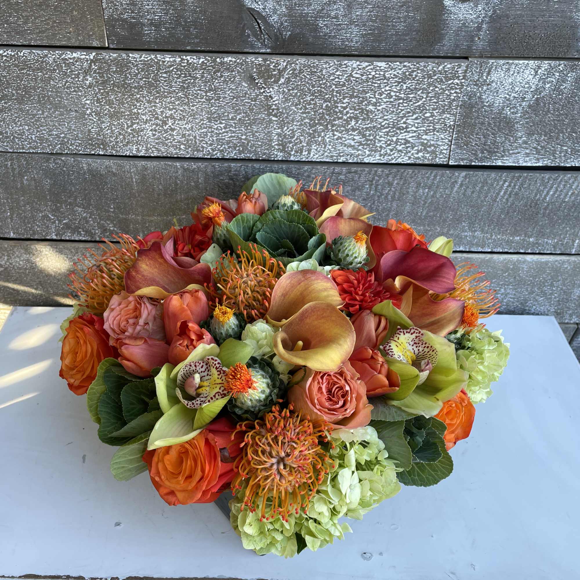 Orange and coral bouquet with calla lilies, roses, and hydrangeas