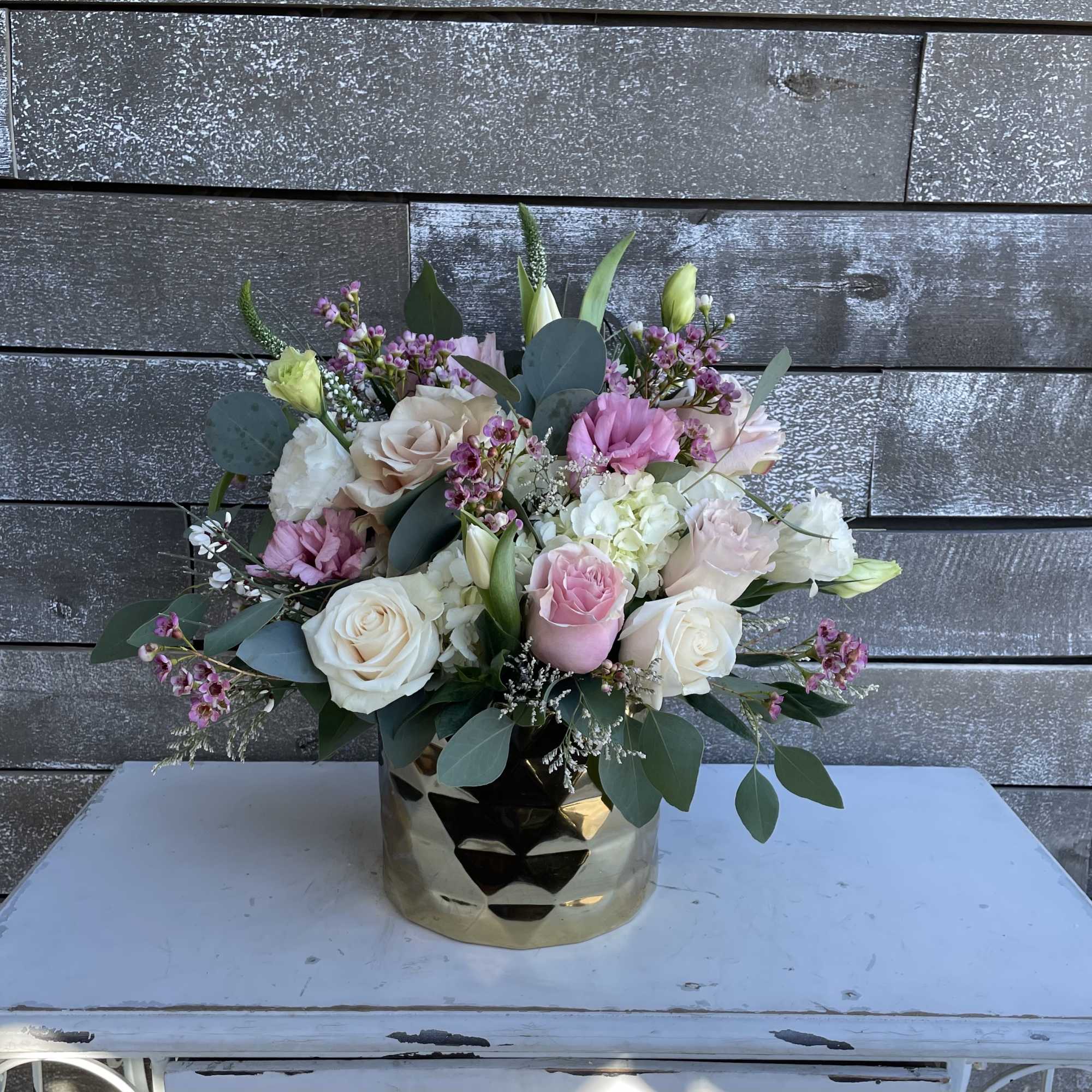 Mixed pink and white rose bouquet in a gold vase