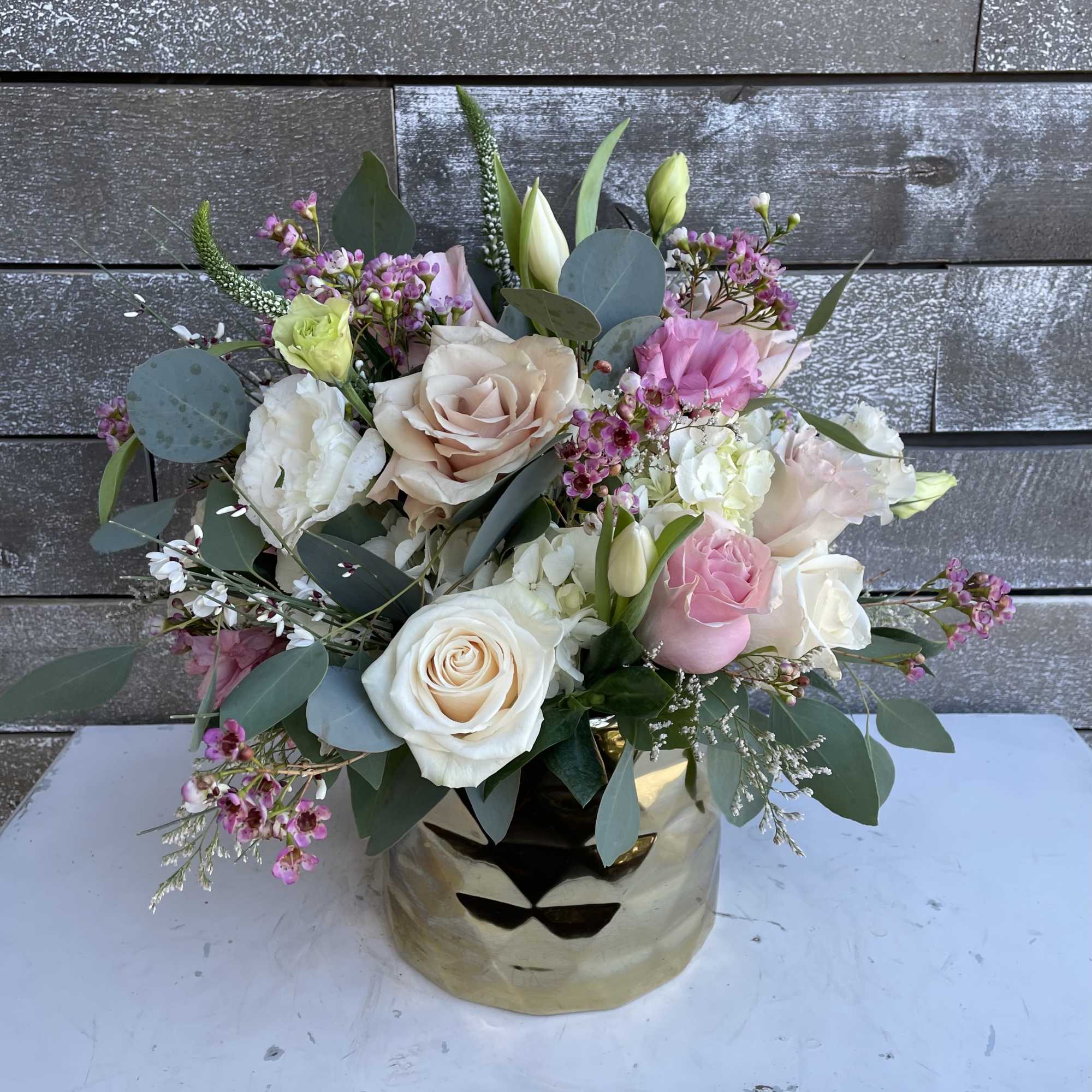 Bouquet of pink and white roses in a gold vase