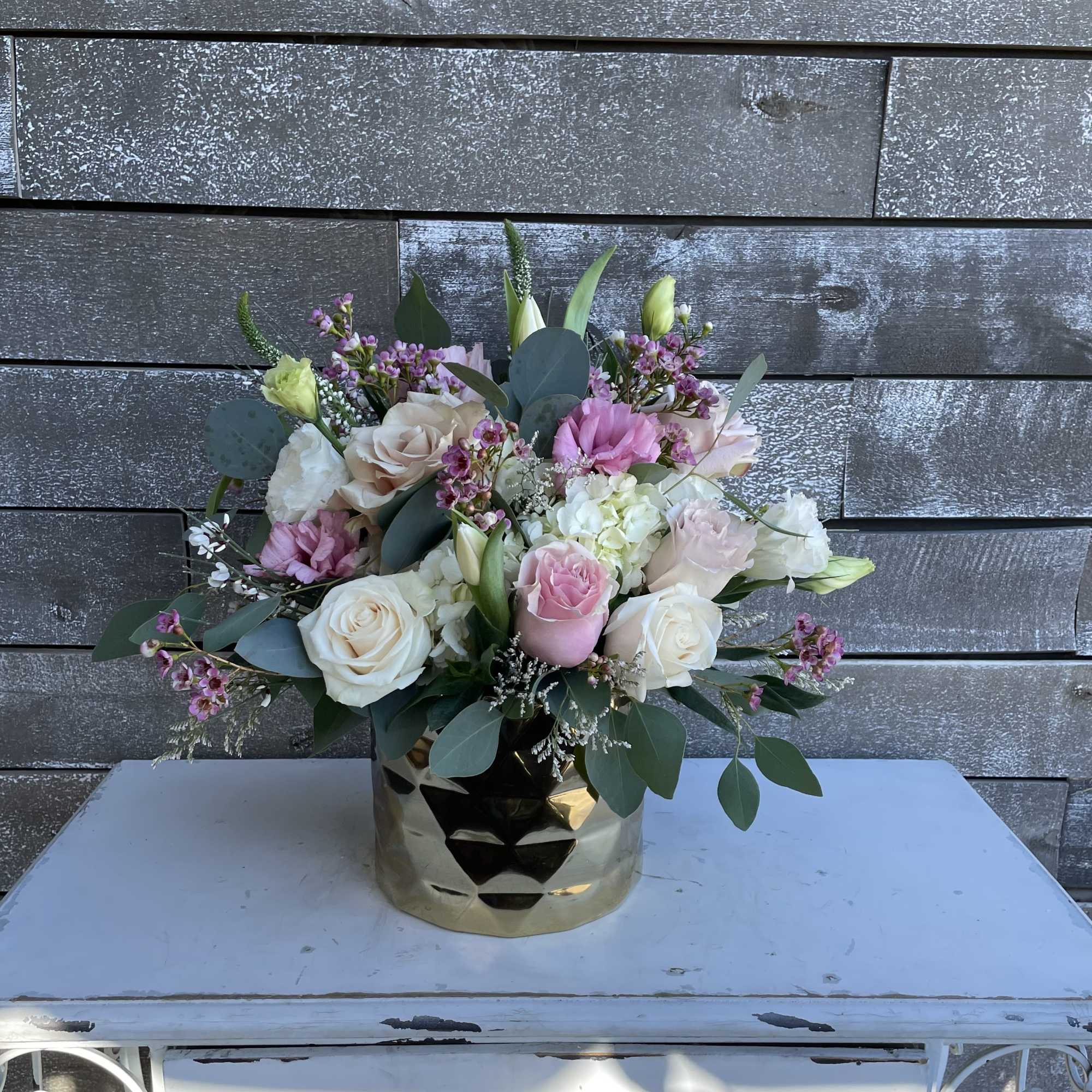 Pink and white rose bouquet in a gold vase