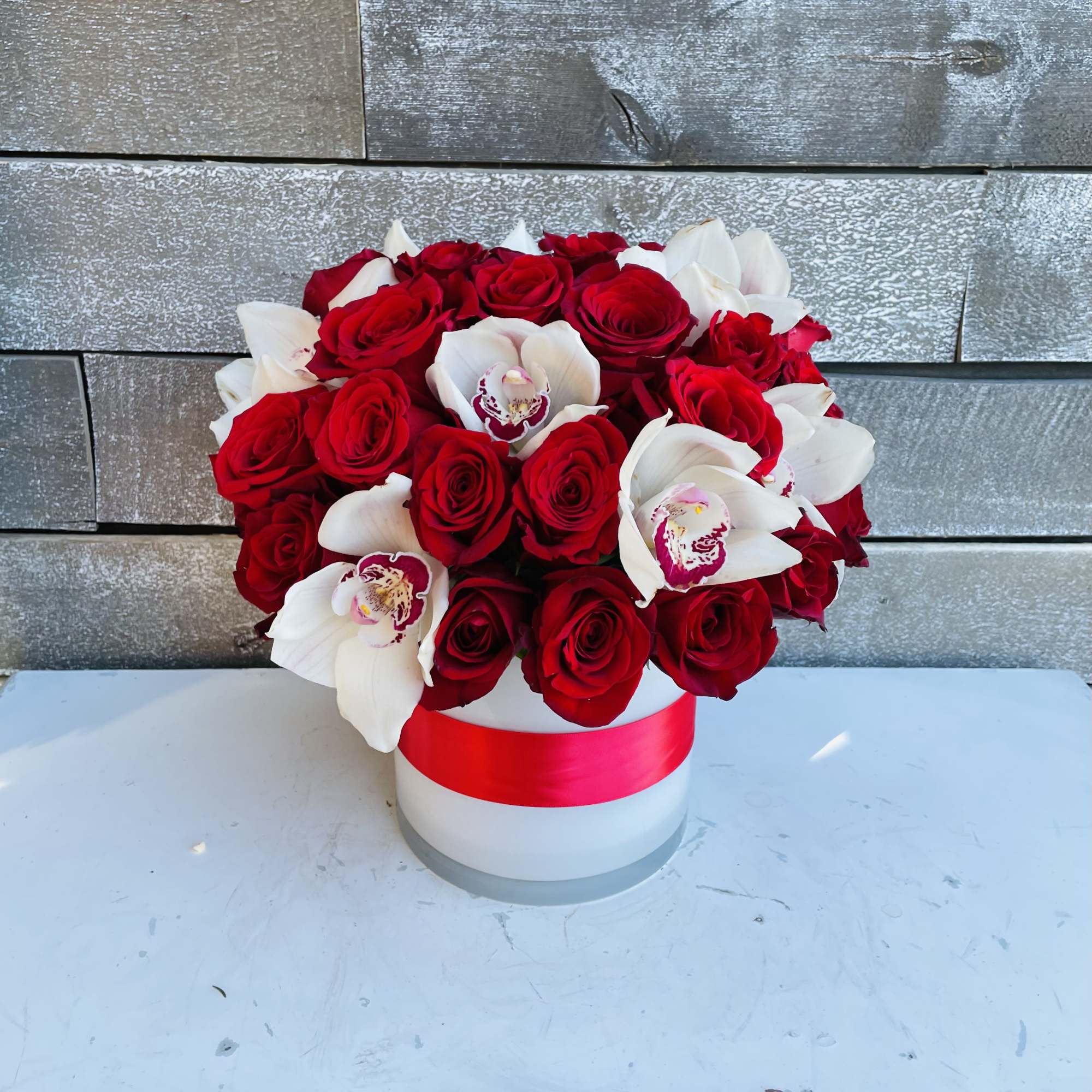 Red roses and white orchids in a white hat box with a red ribbon, photo 4 of 4