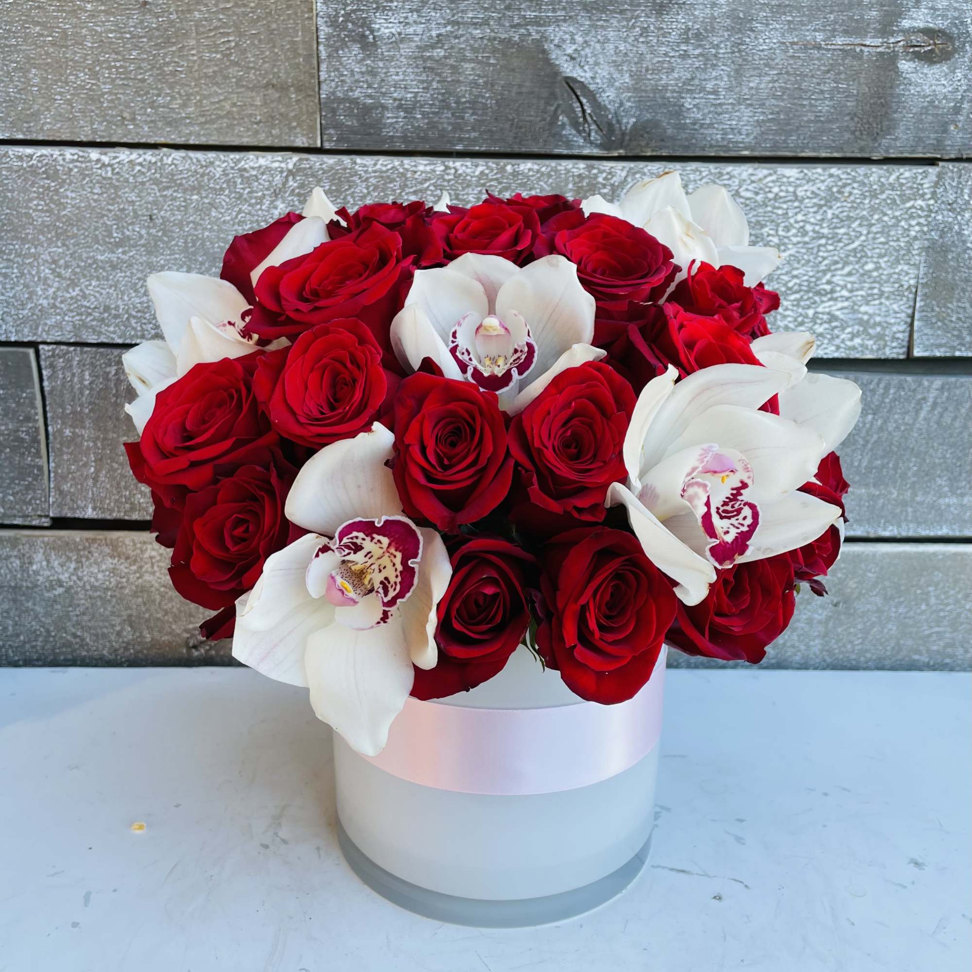 Red roses and white orchids arranged in a white hat box, photo 2 of 3