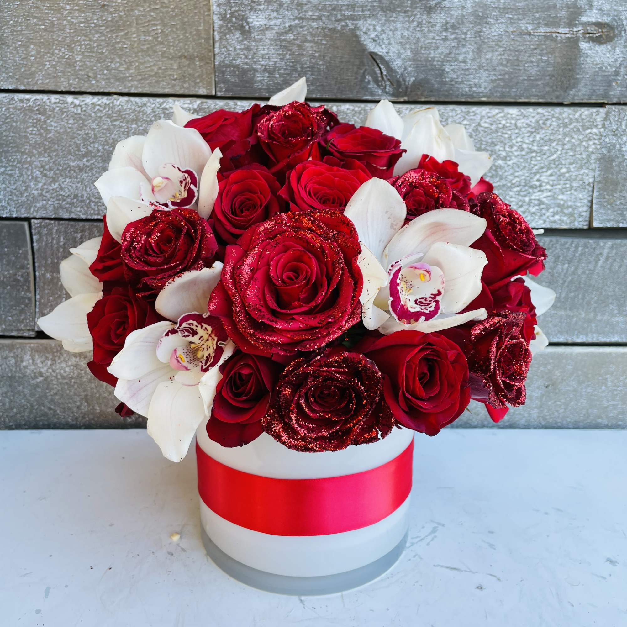 Red roses and white orchids in a white hat box with a red ribbon, photo 3 of 4