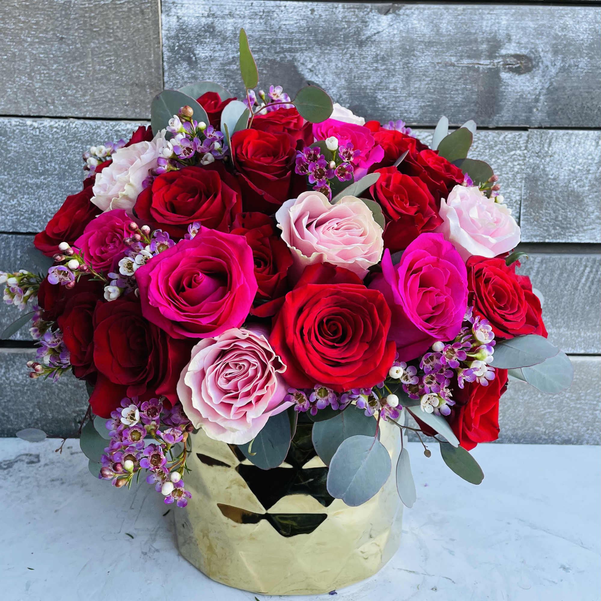 Bouquet of red, pink, and white roses in a gold vase, photo 2 of 2