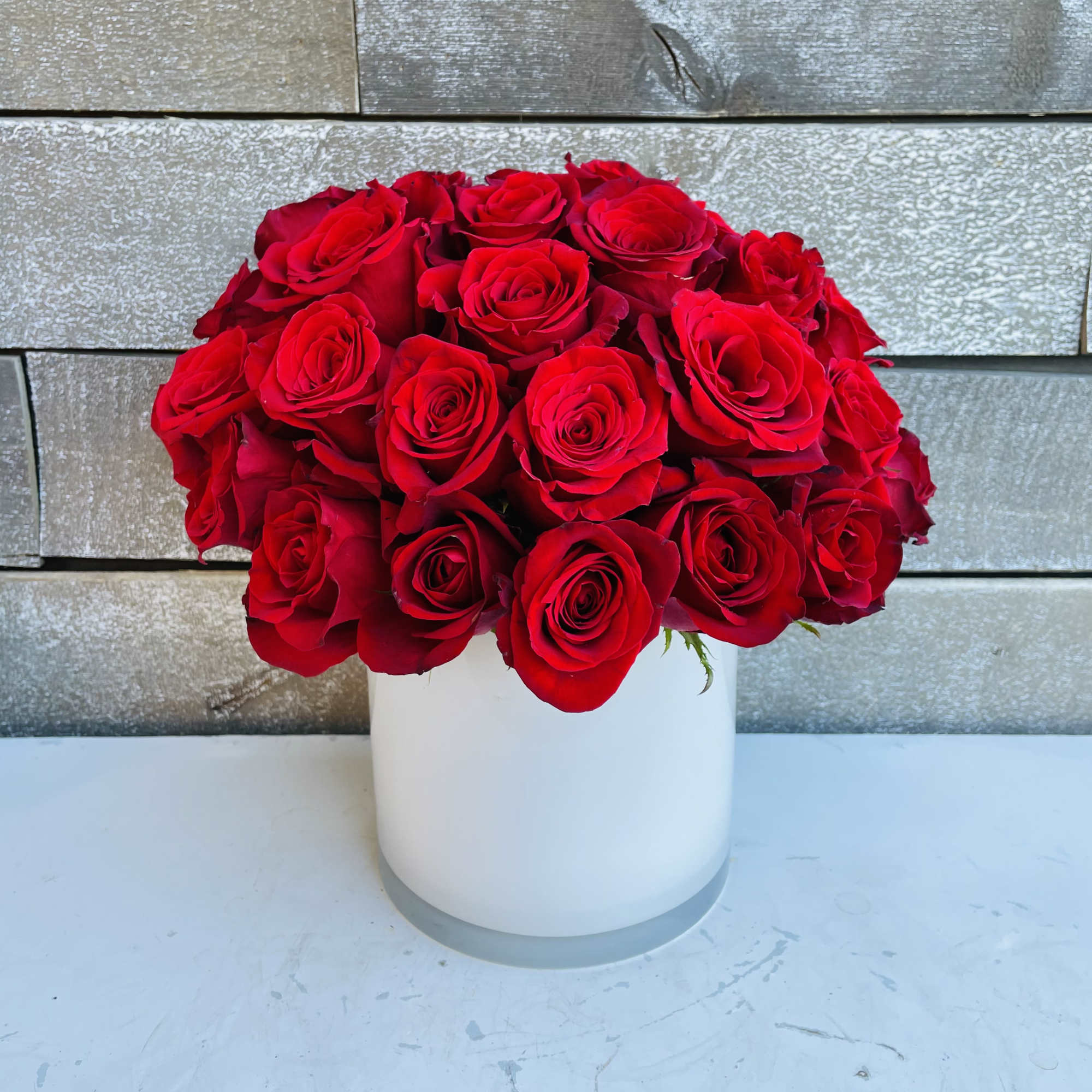 Red rose bouquet in a white cylindrical vase, photo 2 of 4