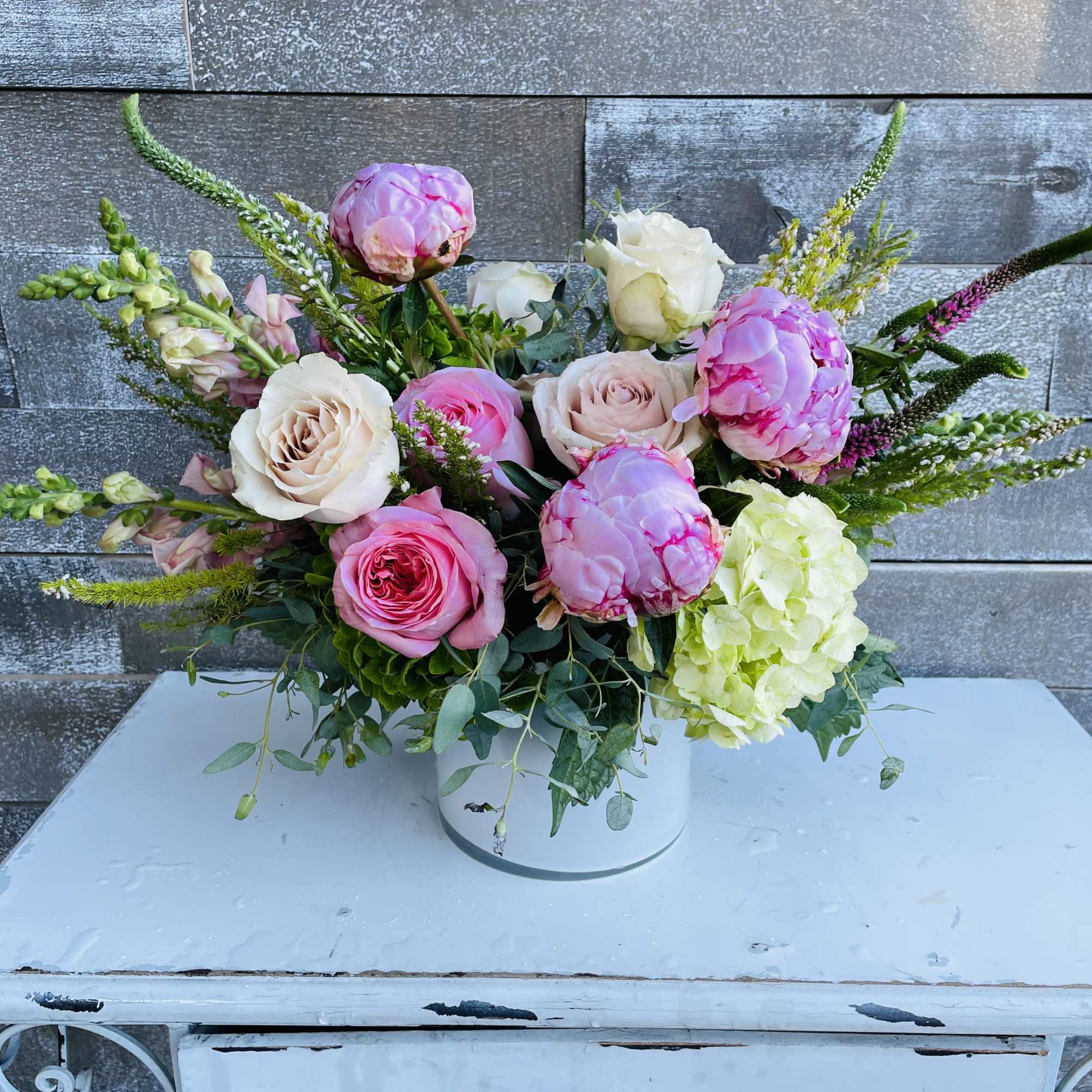 Pink and white rose bouquet with hydrangea in a white vase
