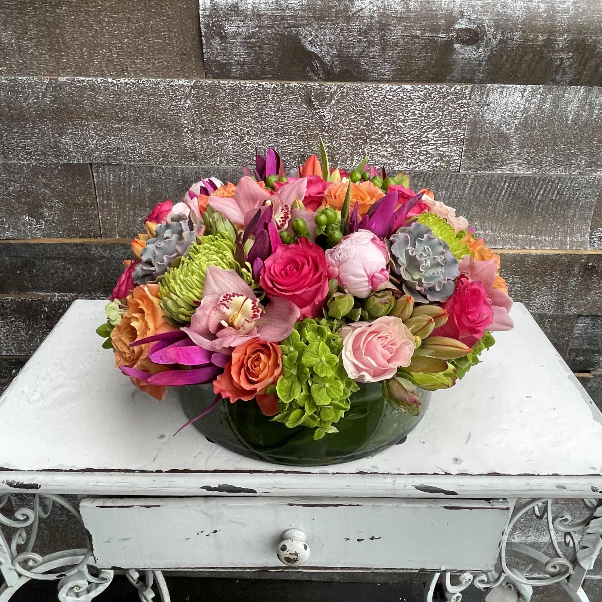 Colorful mixed bouquet in a low green glass bowl