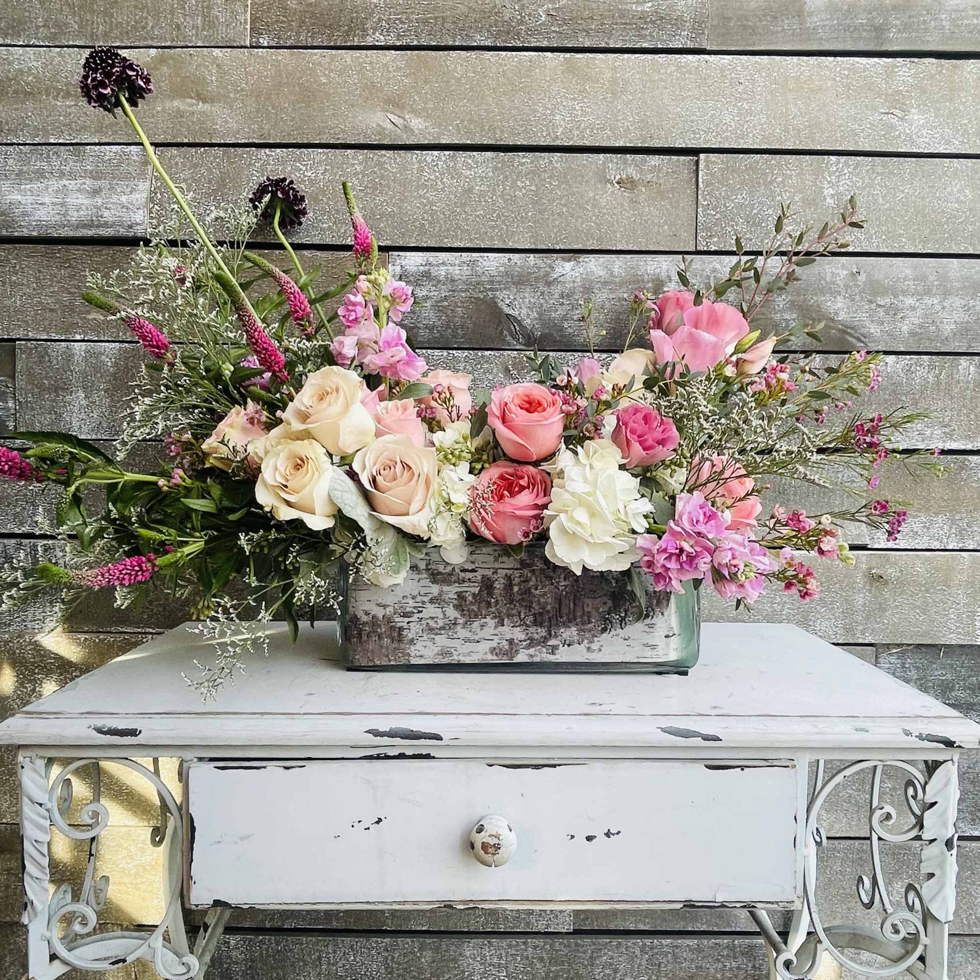 Mixed pink and cream floral arrangement in a rectangular vase