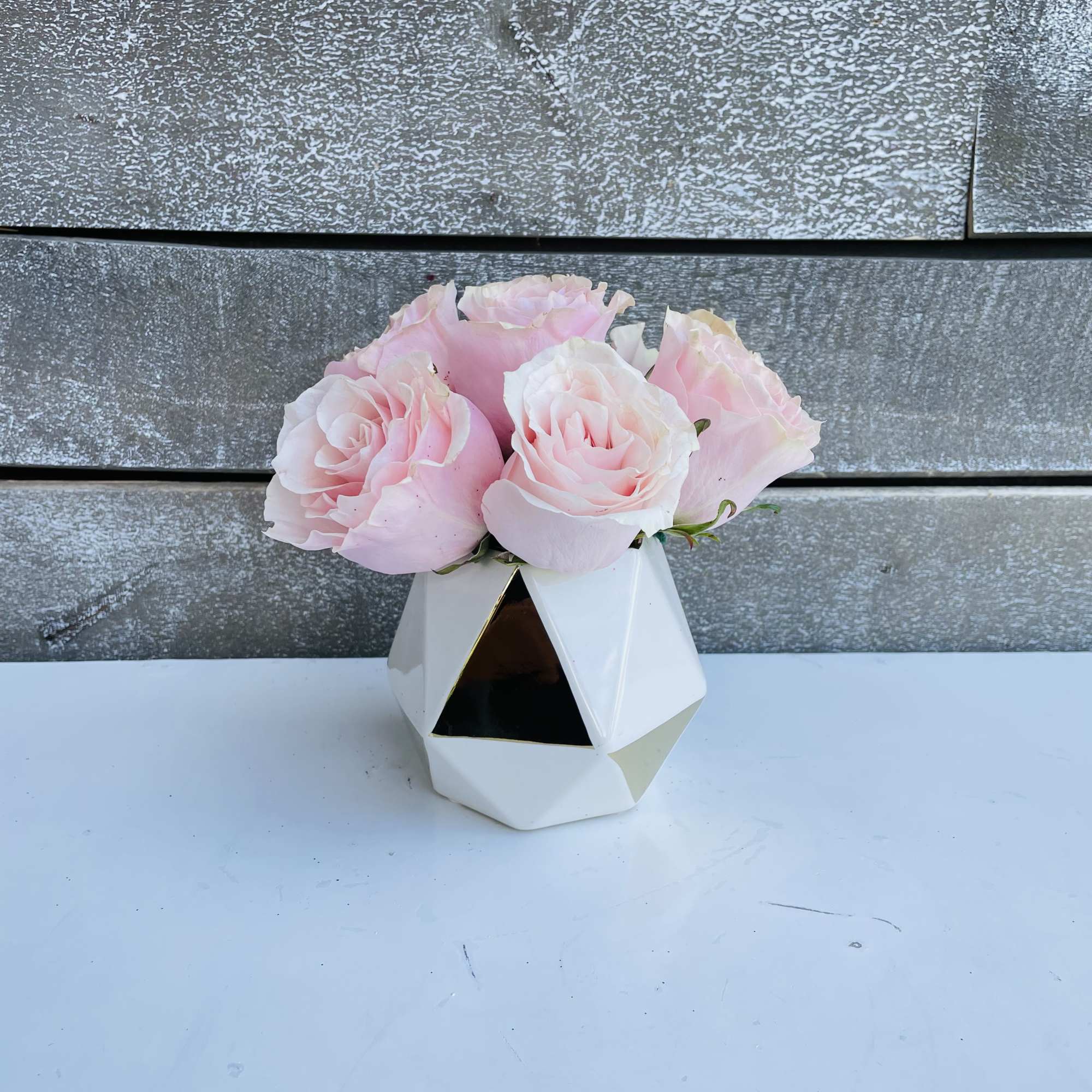 Pink roses in a white geometric vase