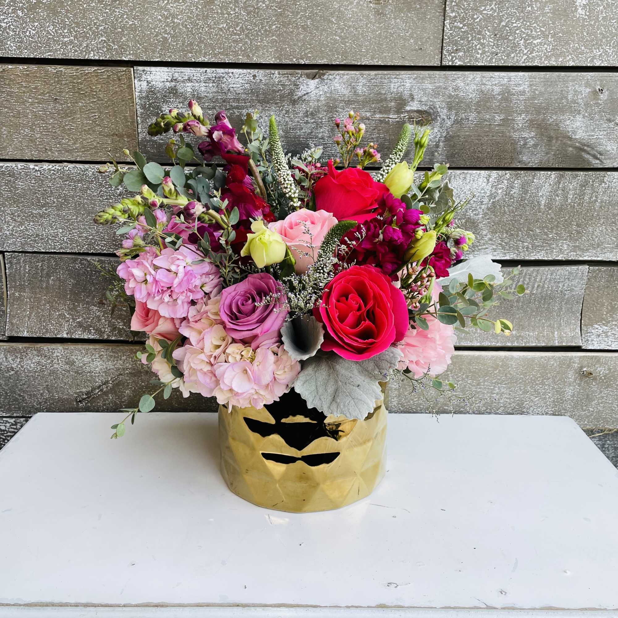 Mixed pink and red flower arrangement in a gold vase, photo 2 of 2
