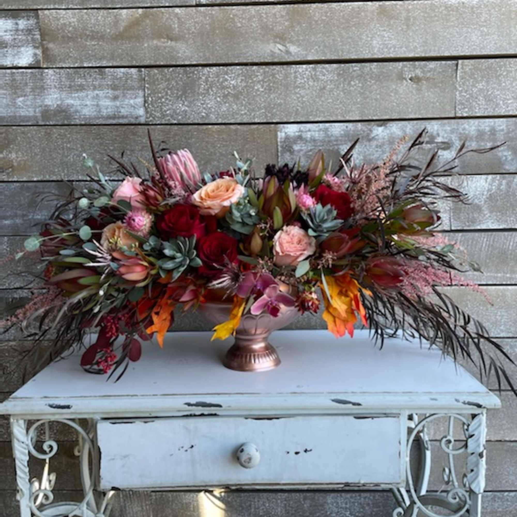 Large mixed floral arrangement in a copper vase