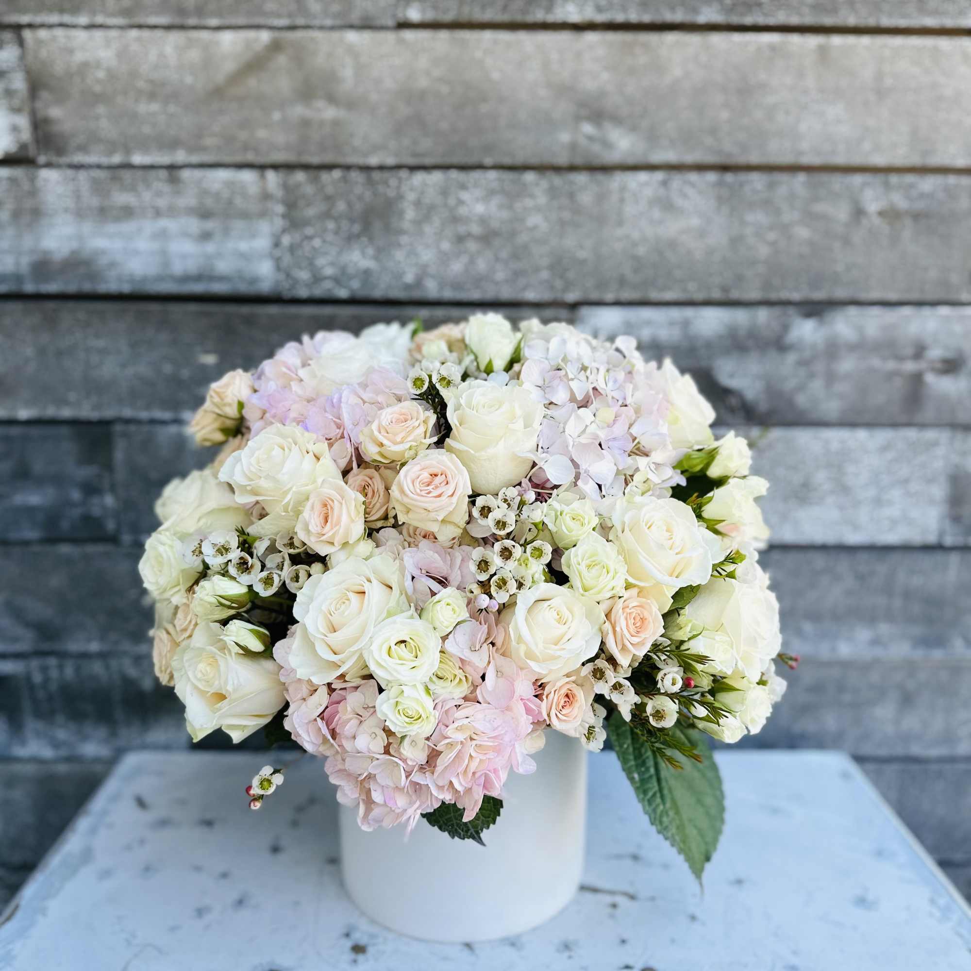 Bouquet of white and blush roses in a white vase