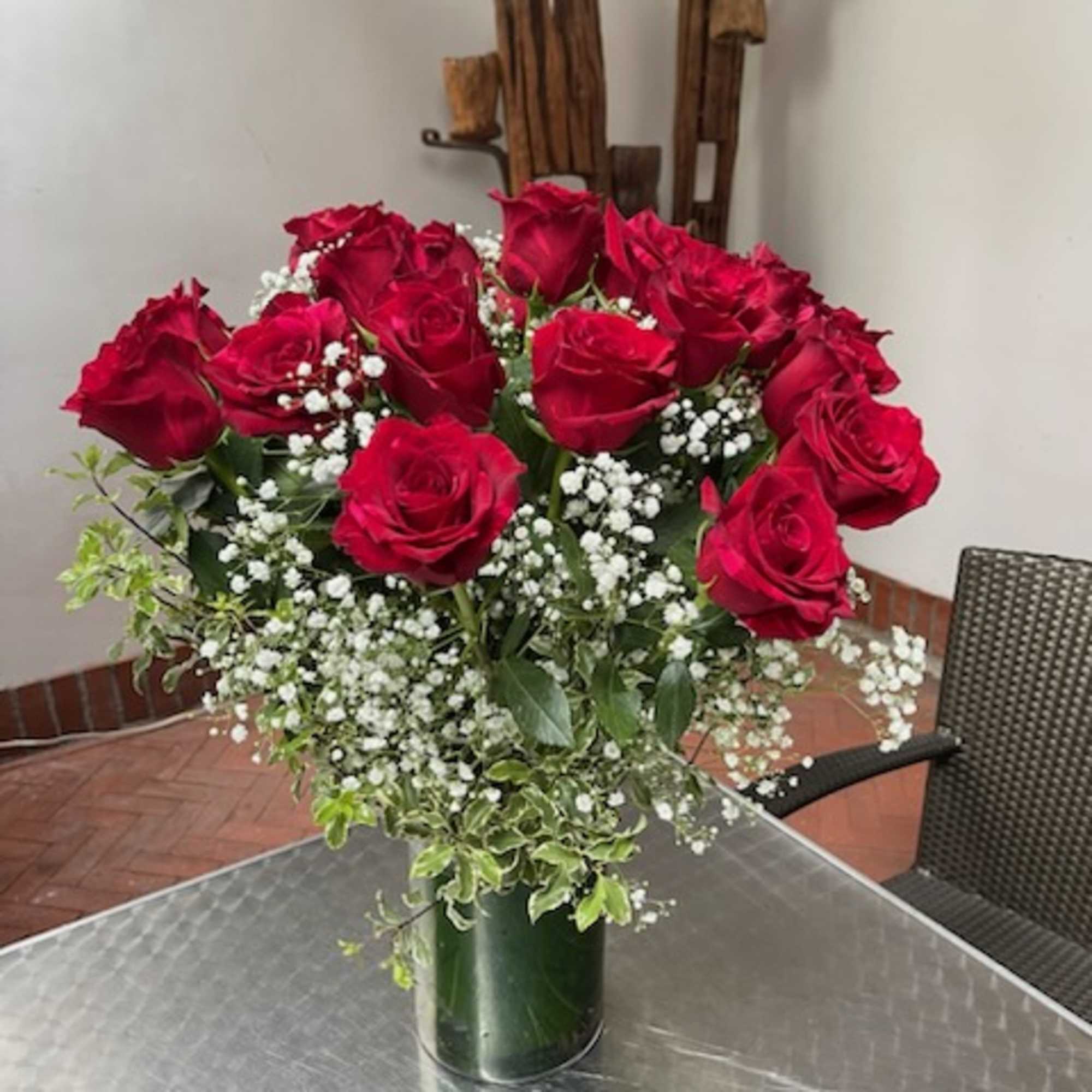Red roses with baby's breath in a glass vase