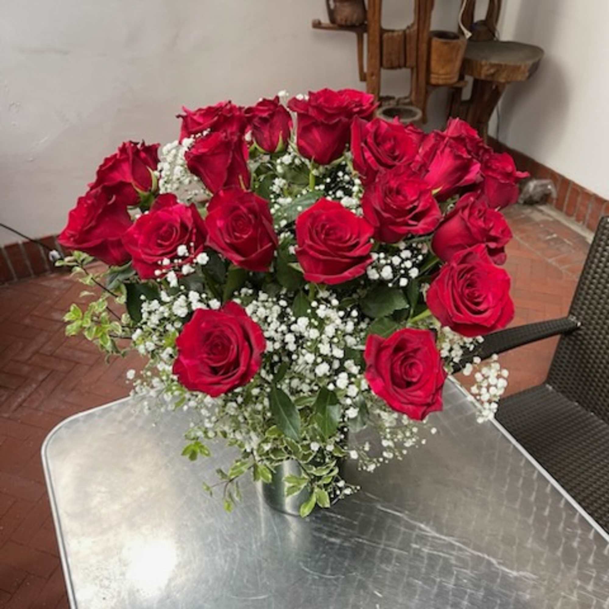 Bouquet of red roses with white baby's breath in a metal vase