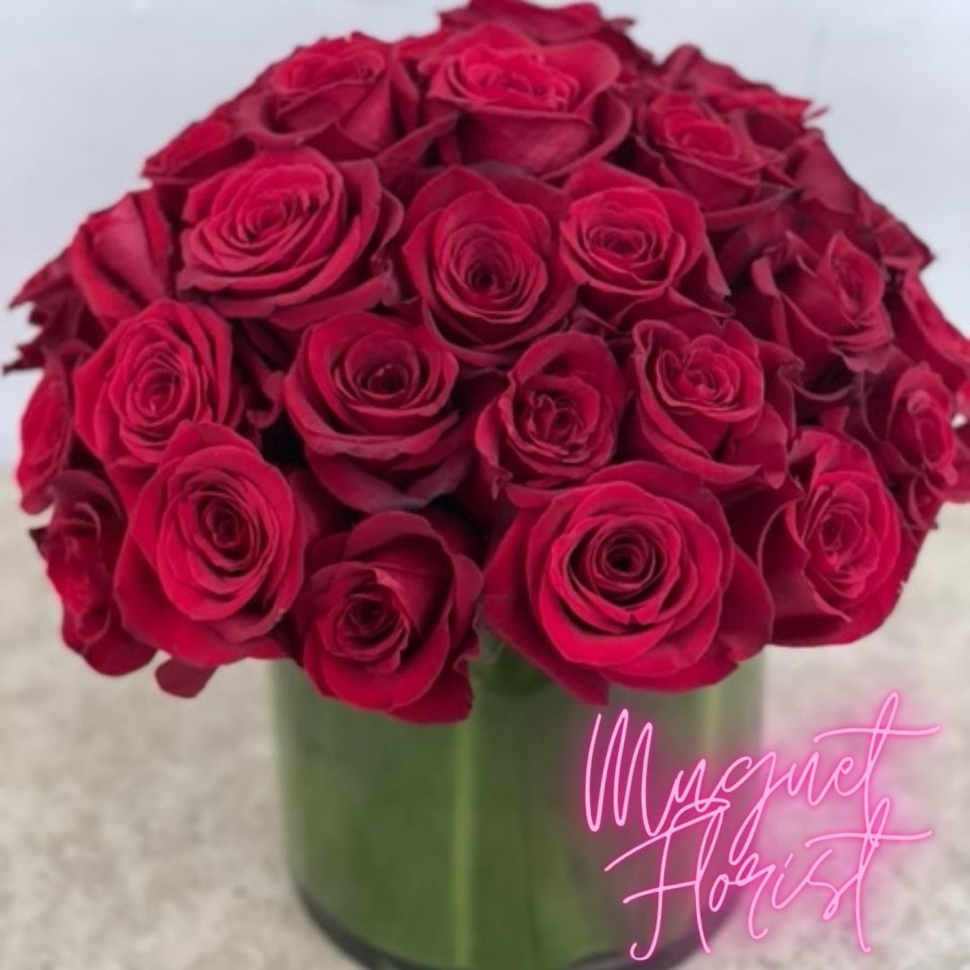 Bouquet of deep red roses in a green glass vase