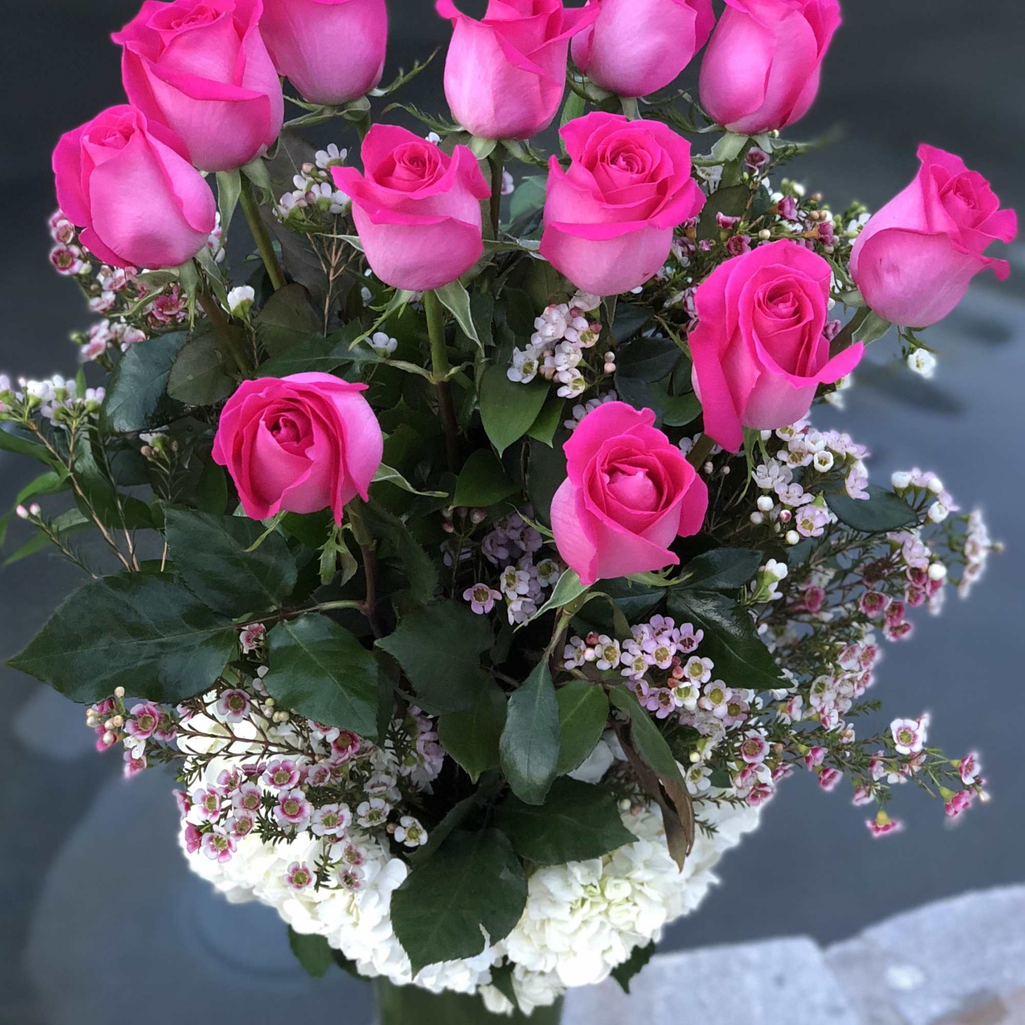 Pink roses arranged in a clear glass vase with white filler flowers