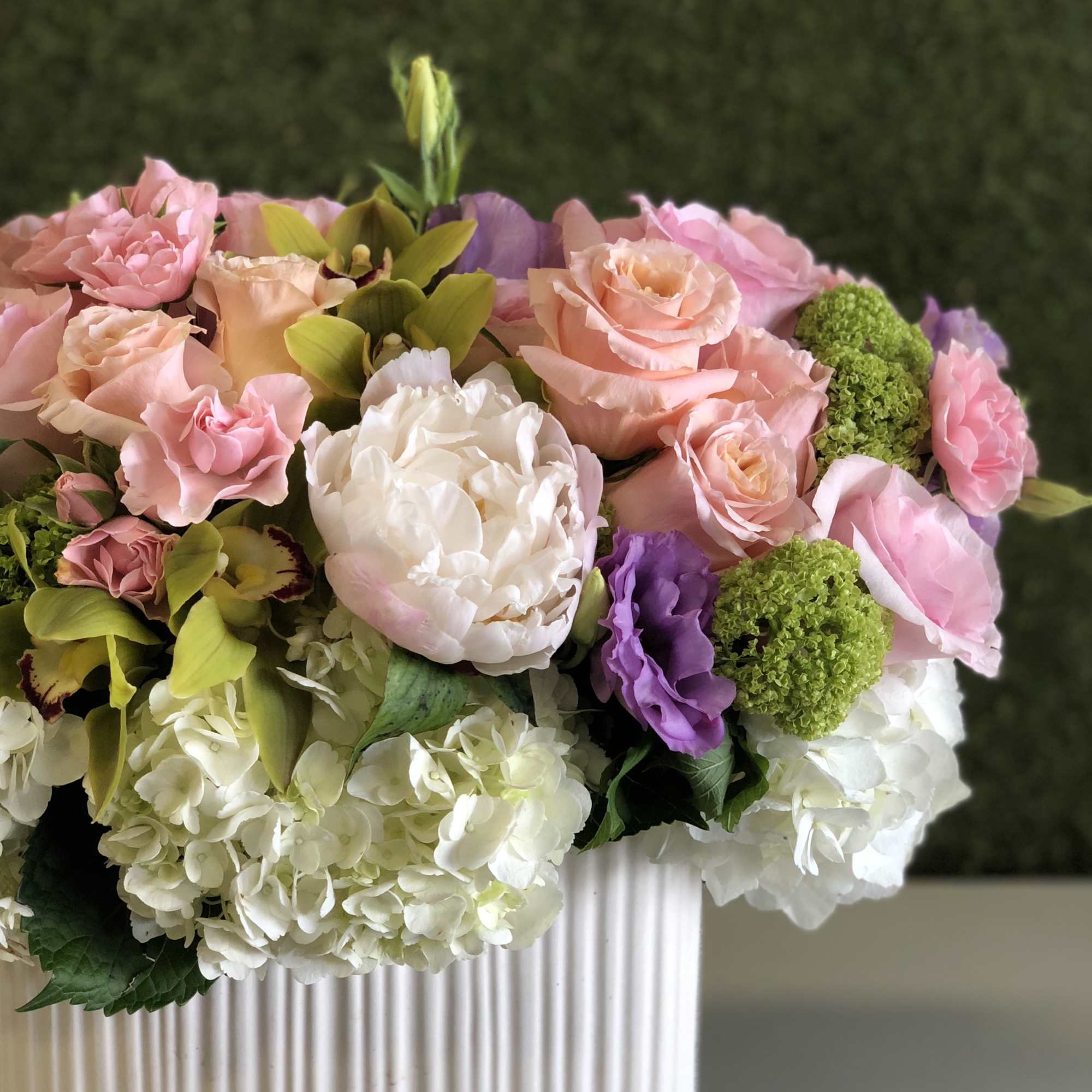 Pastel flower arrangement in a white ribbed vase