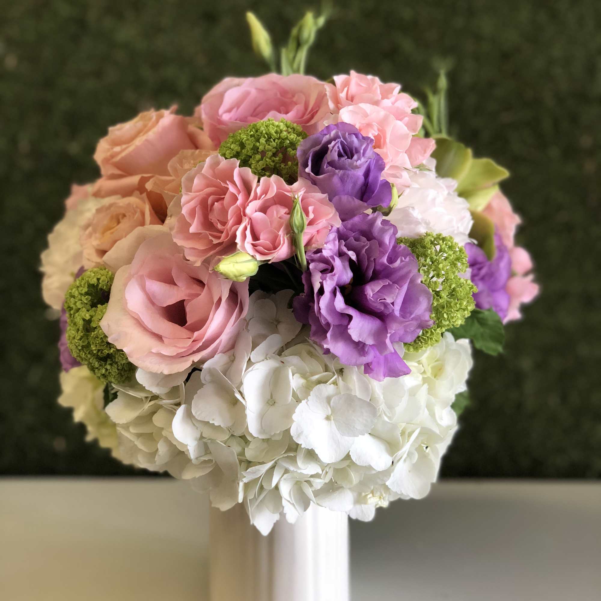 Pink, purple, and white bouquet in a white vase