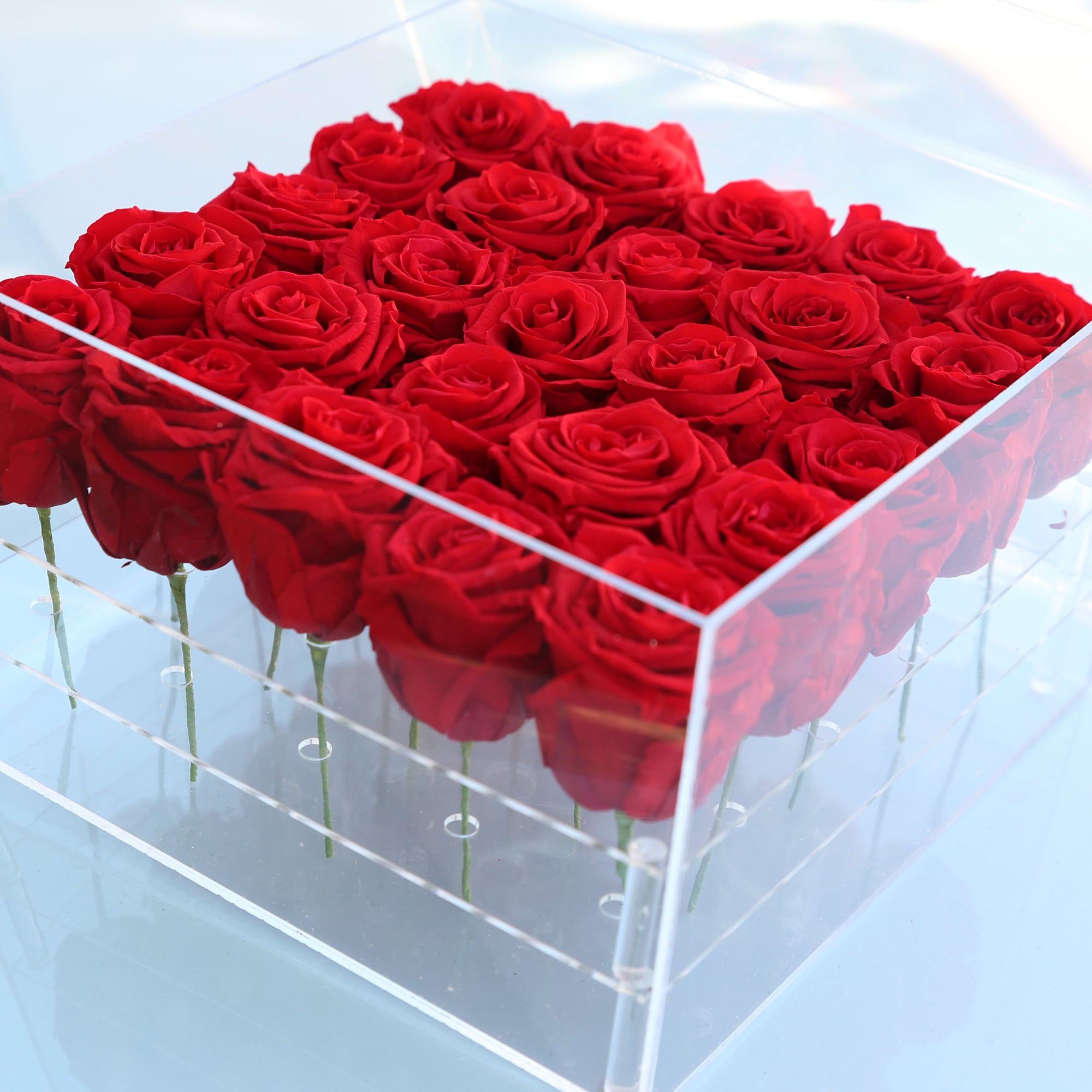 Box of red roses in a clear acrylic container