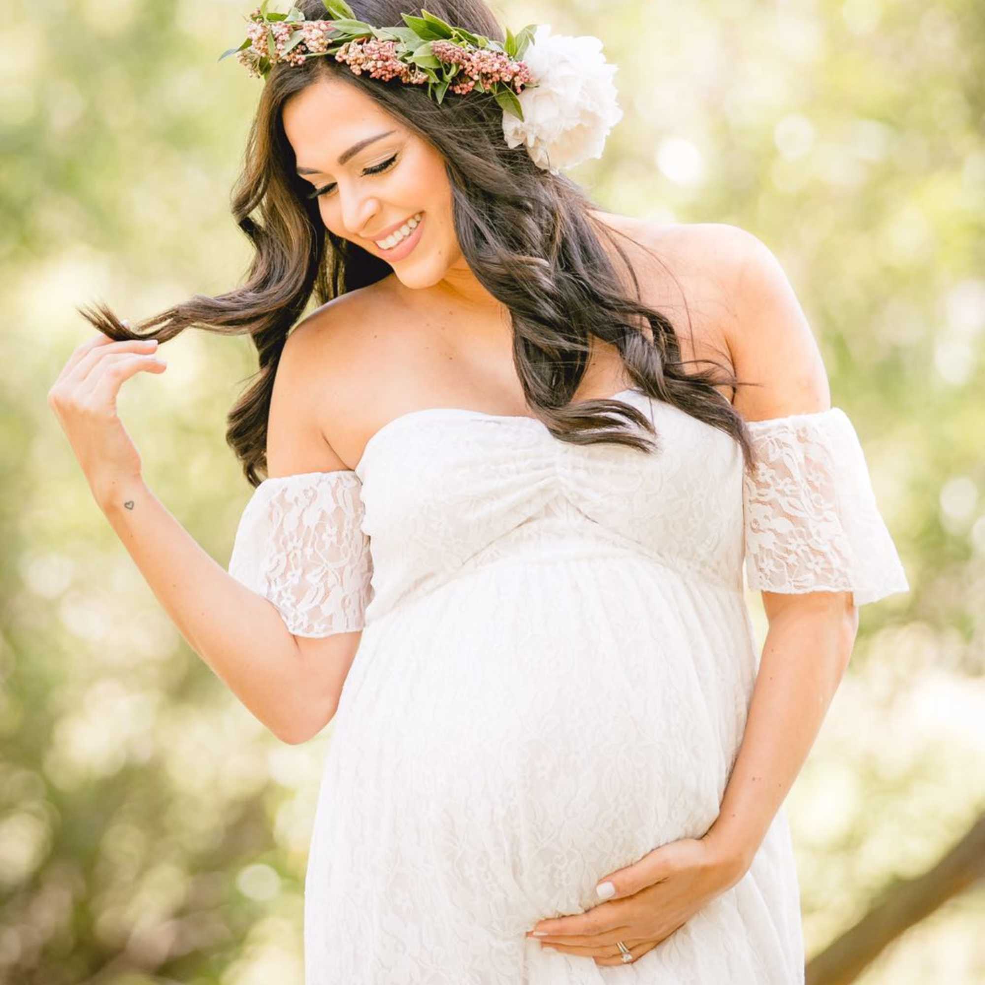Pregnant woman in a white dress wearing a floral crown