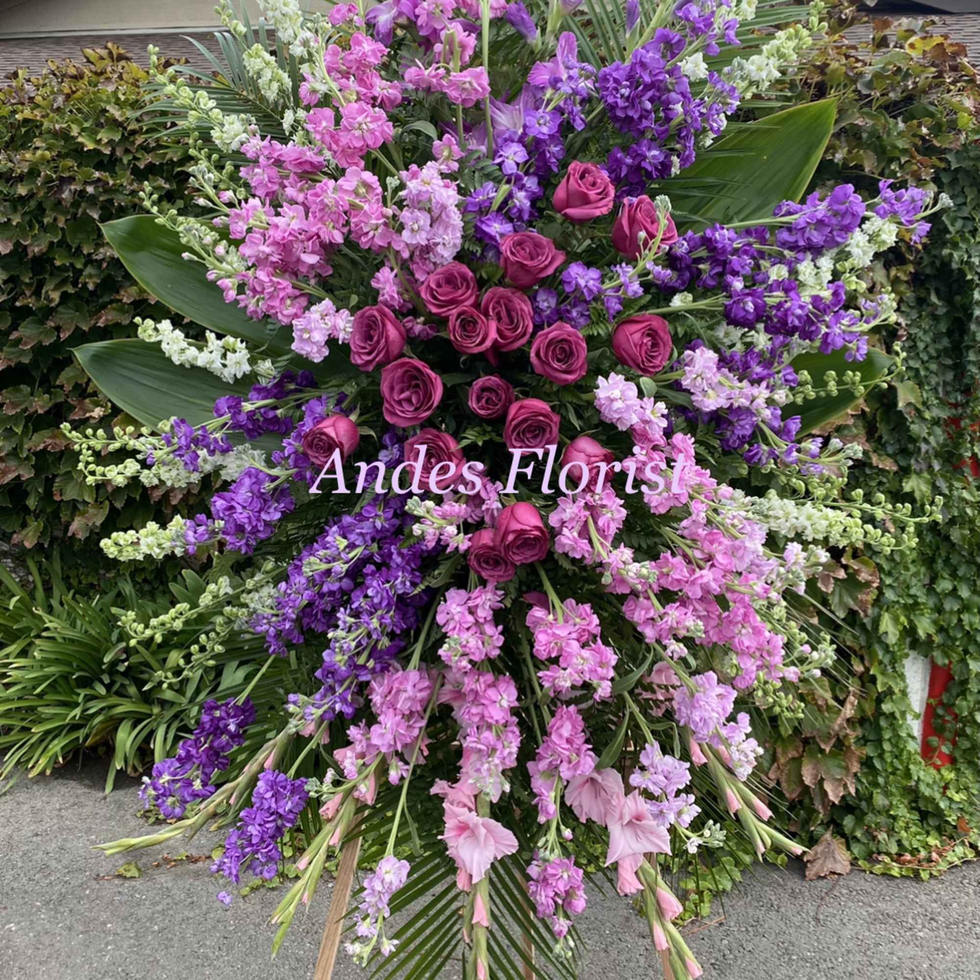Large standing floral spray with pink and purple roses and blossoms